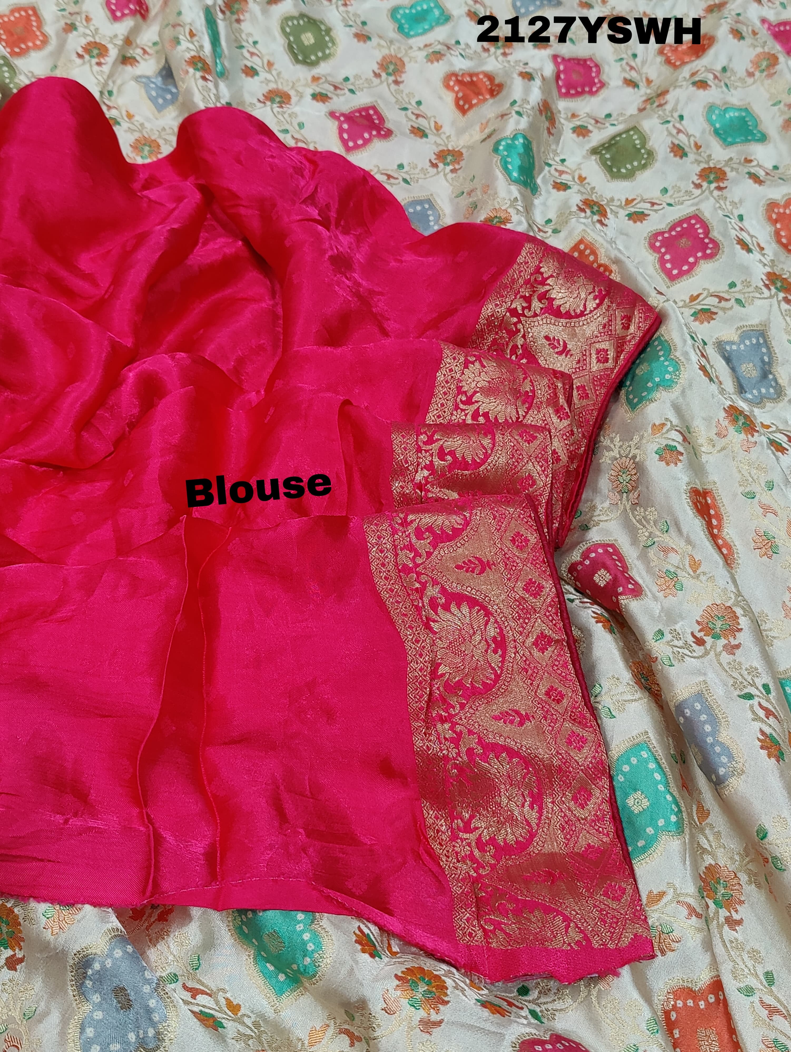 A Banarasi silk saree with a Meenakari pattern featuring a cream body with multicolor floral designs and a red border.
