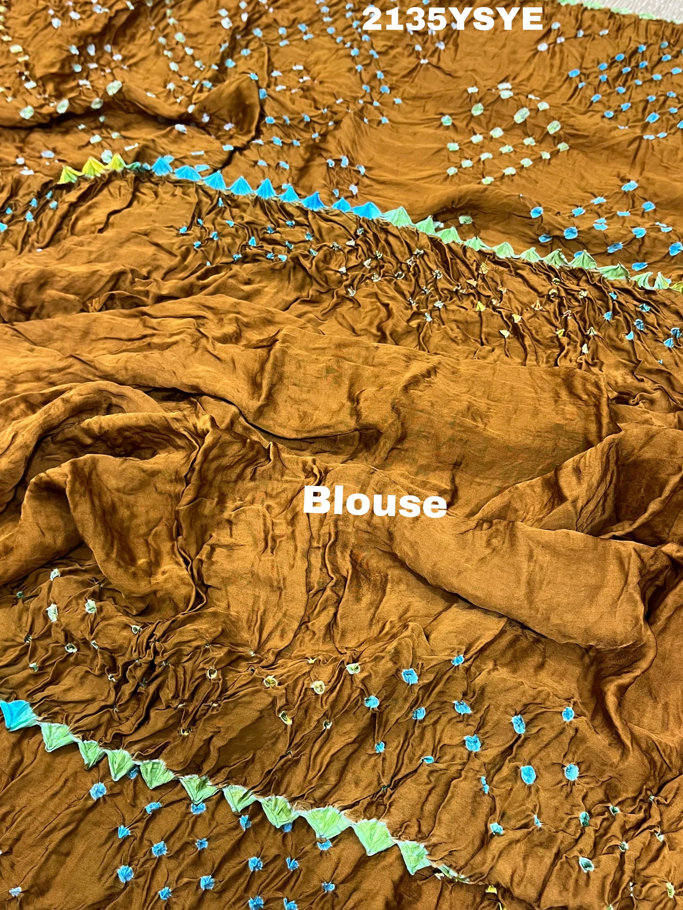 A brown and yellow silk saree with bandhani style dots and a metallic border.