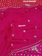 A saree with a bandhani pattern and cutdana work, predominantly pink with red accents.