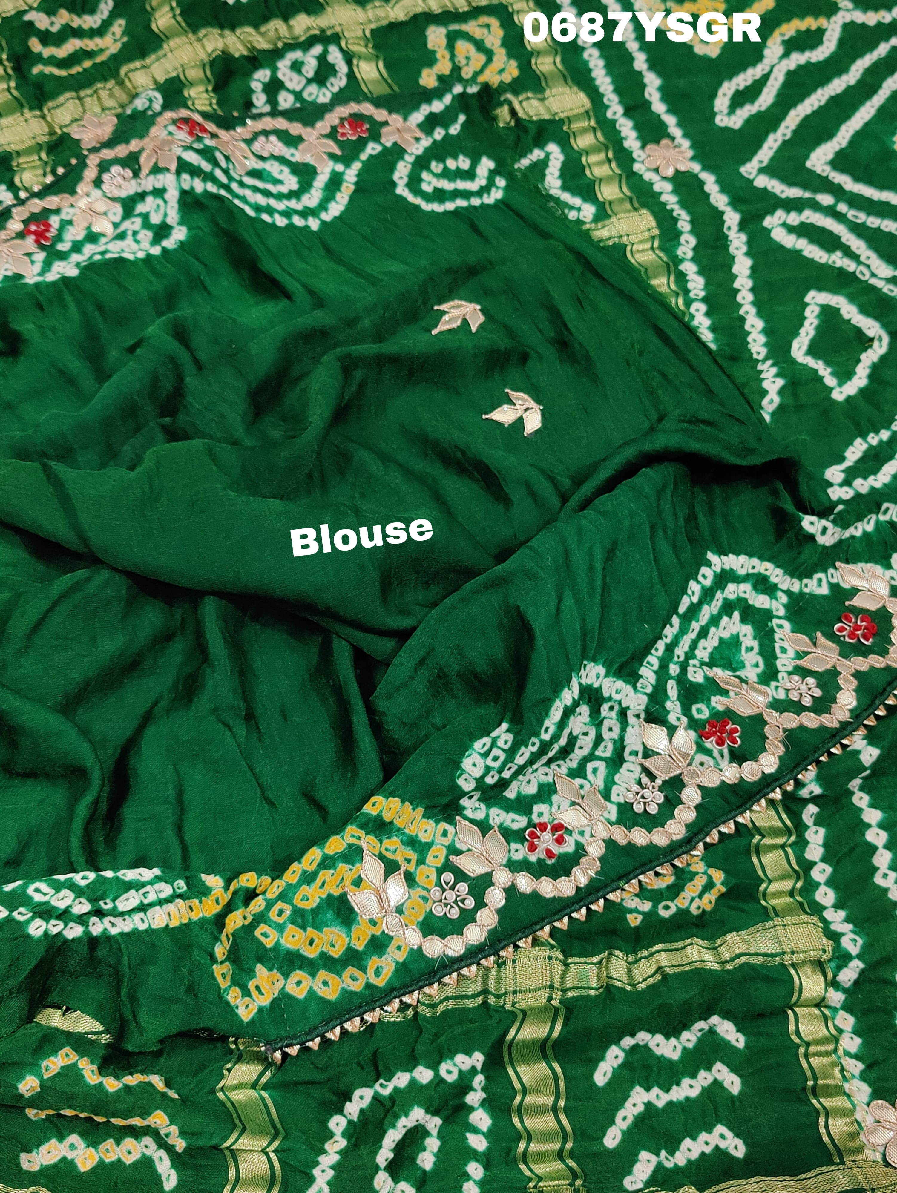 A green and silver pure gaji silk saree with bandhani pattern and gotapatti handwork, displayed on a surface.