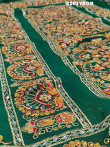 A green saree with red bandhej patterns and royal aari work, along with real mirror work on the border.