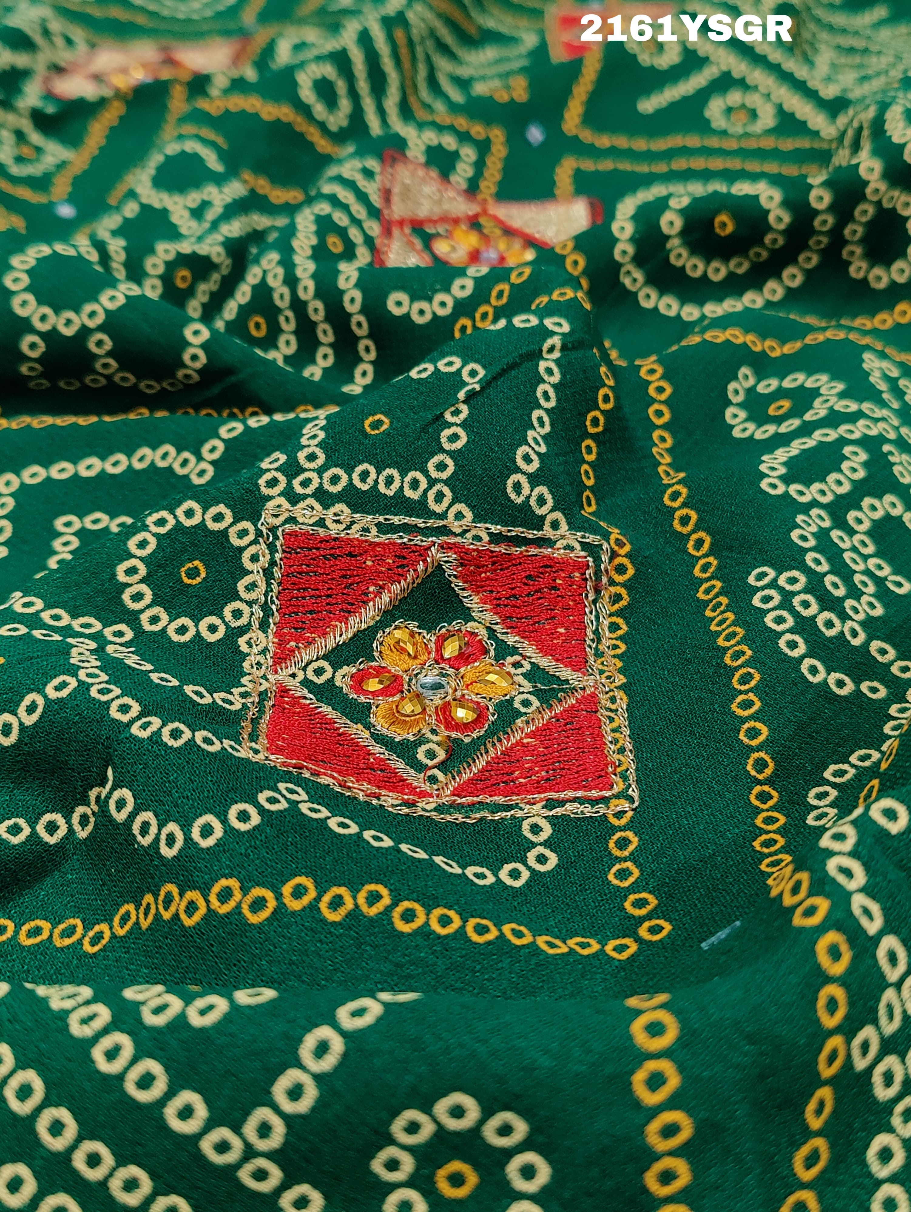 A green saree with red bandhej patterns and royal aari work, along with real mirror work on the border.