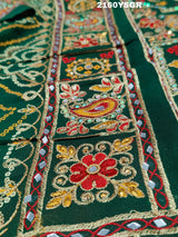 A green bandhej saree with royal aari and real mirror work, displayed on a surface.