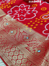 A red and silver bandhani style silk saree with mirror handwork, including floral patterns and a traditional design.