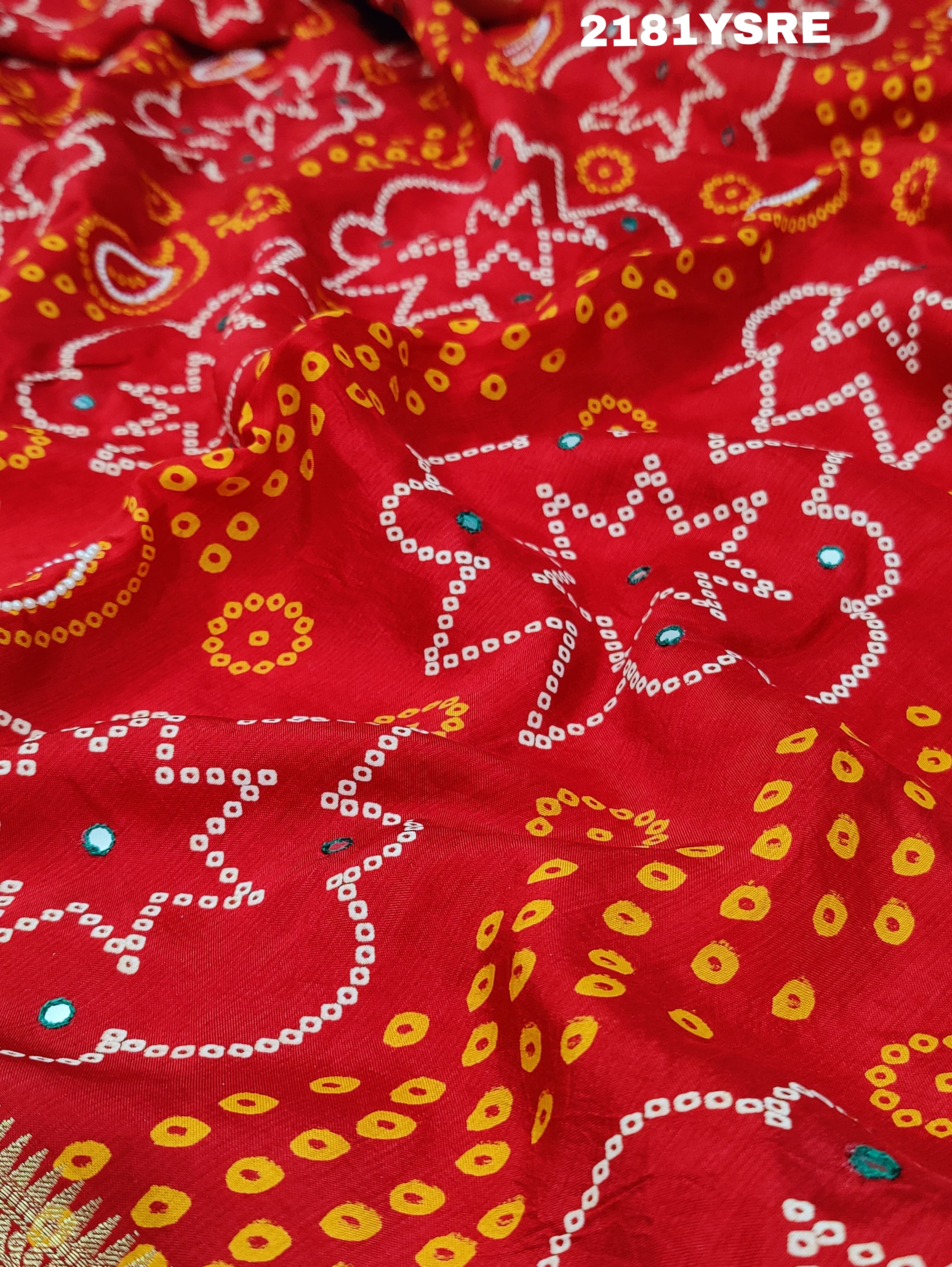 A red and silver bandhani style silk saree with mirror handwork, including floral patterns and a traditional design.