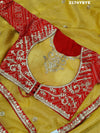 A yellow and red tissue silk saree with Bollywood style embellishments and gotapatti work.