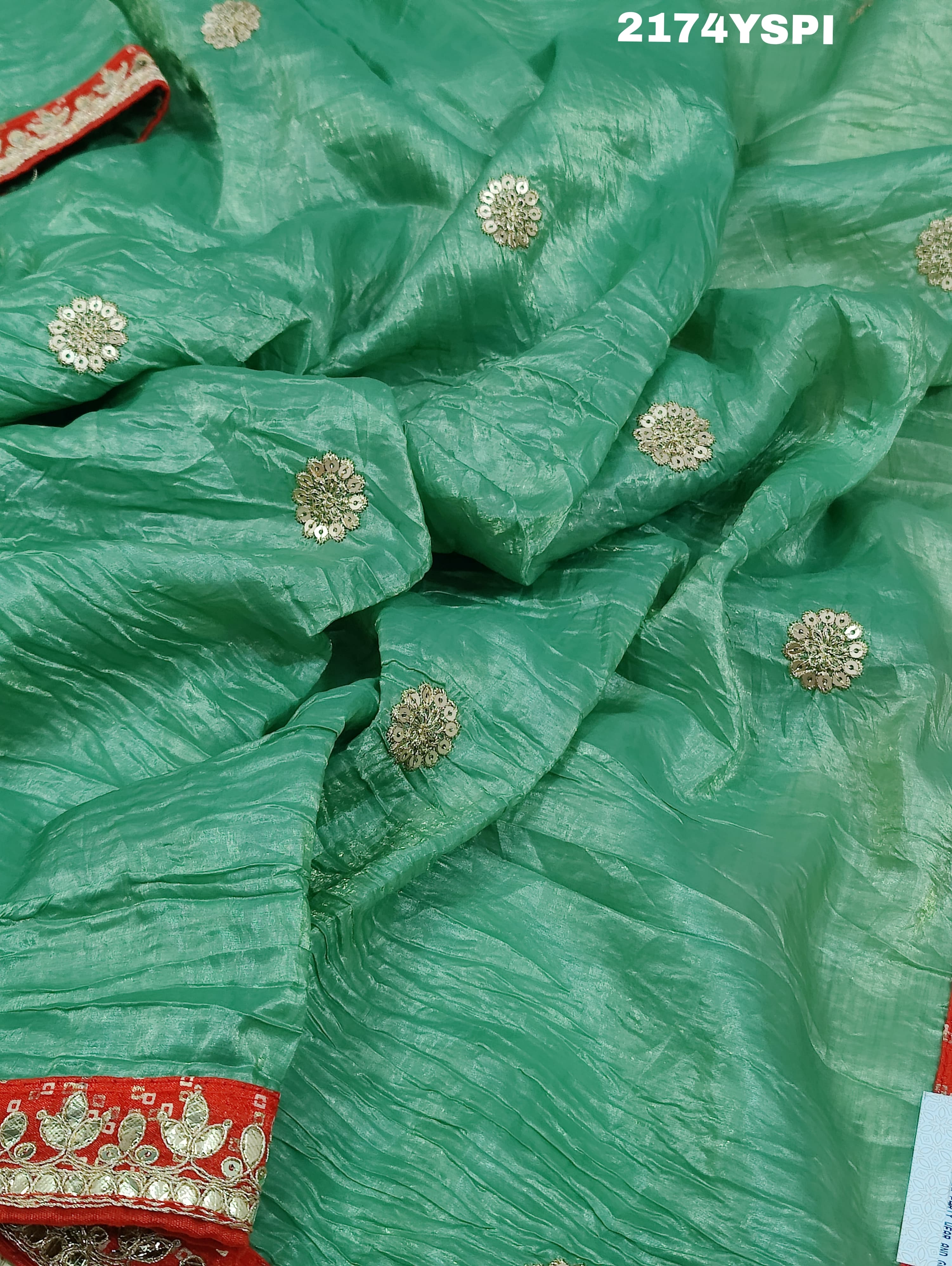A green and red tissue silk saree with Bollywood style embellishments and gotapatti work.
