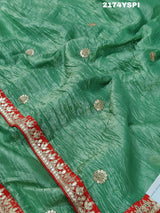 A green and red tissue silk saree with Bollywood style embellishments and gotapatti work.
