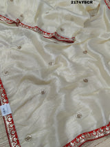 A red and white tissue silk saree with Bollywood style embellishments and gotapatti work.