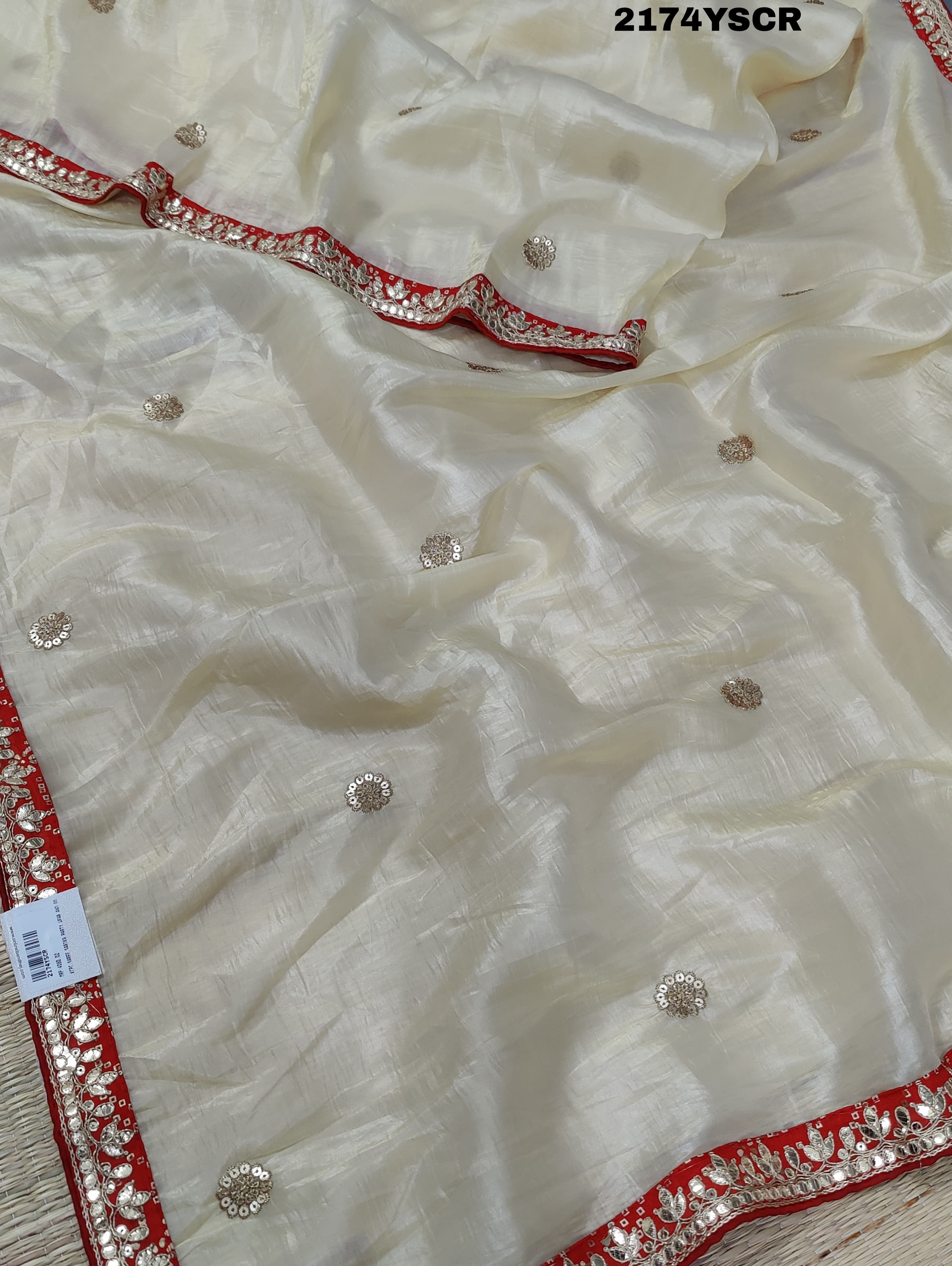 A red and white tissue silk saree with Bollywood style embellishments and gotapatti work.