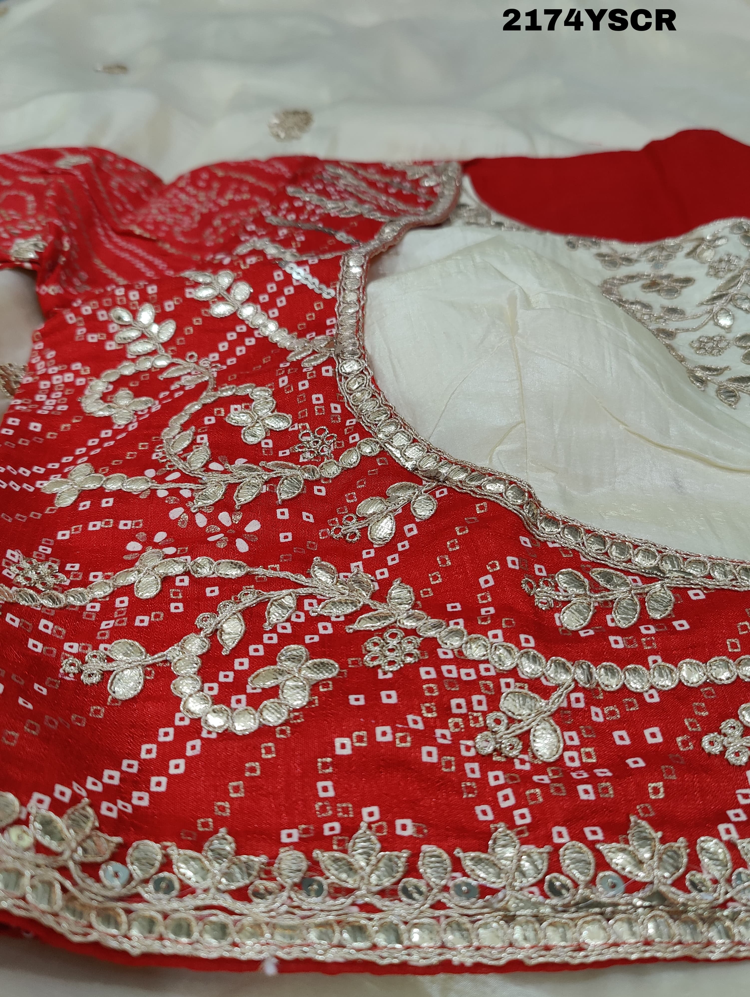 A red and white tissue silk saree with Bollywood style embellishments and gotapatti work.