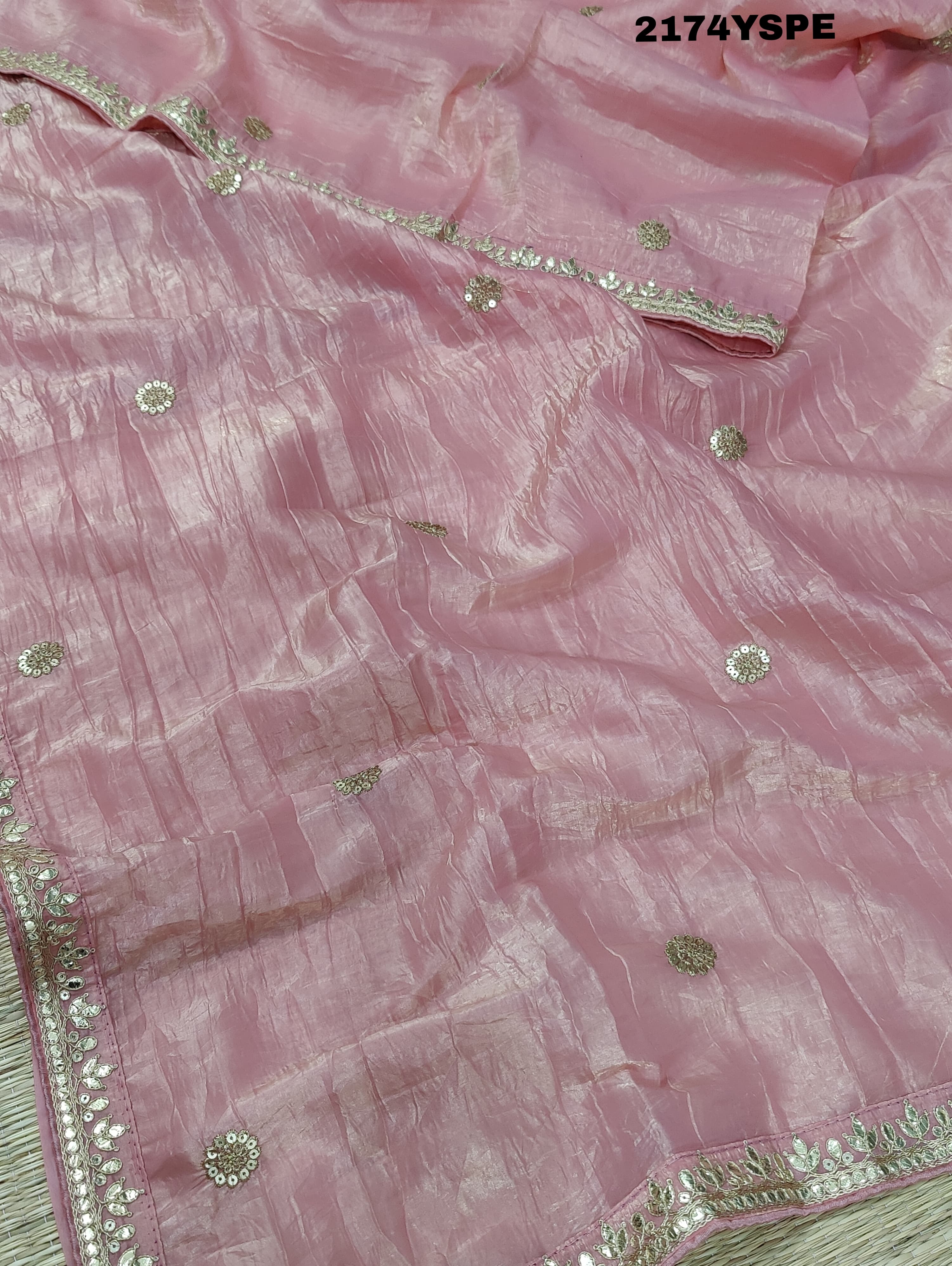A saree with tissue silk fabric featuring Bollywood style embellishments and gotapatti work in red and pink colour