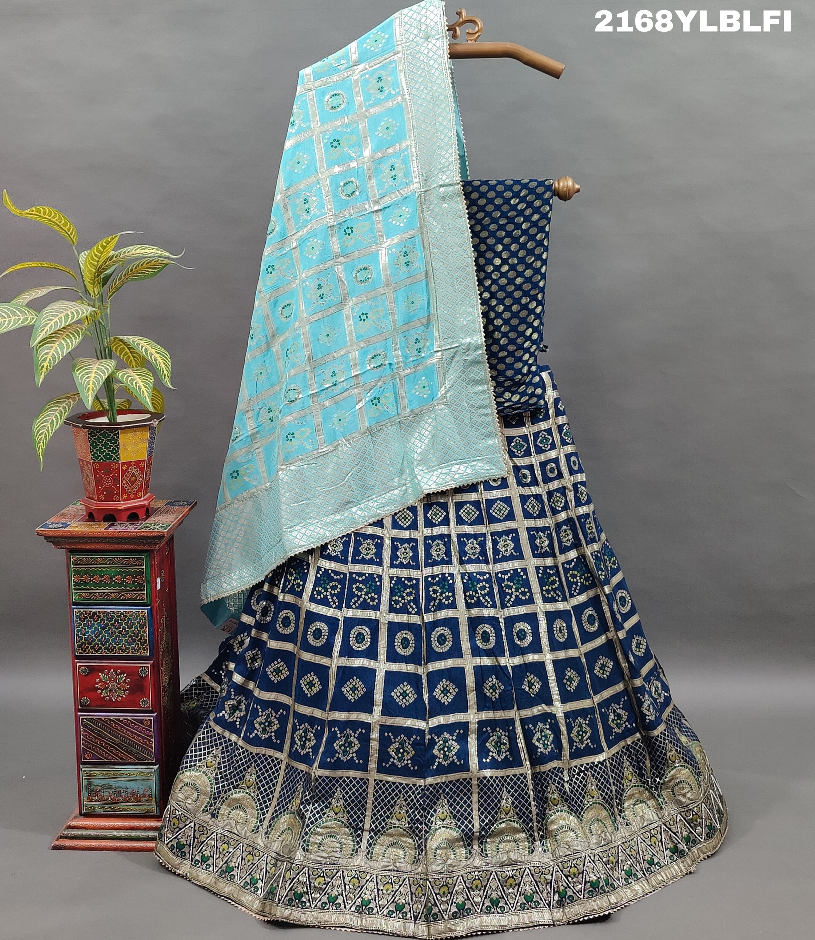A traditional Indian lehenga with a blue and silver silk base and detailed cutdana work