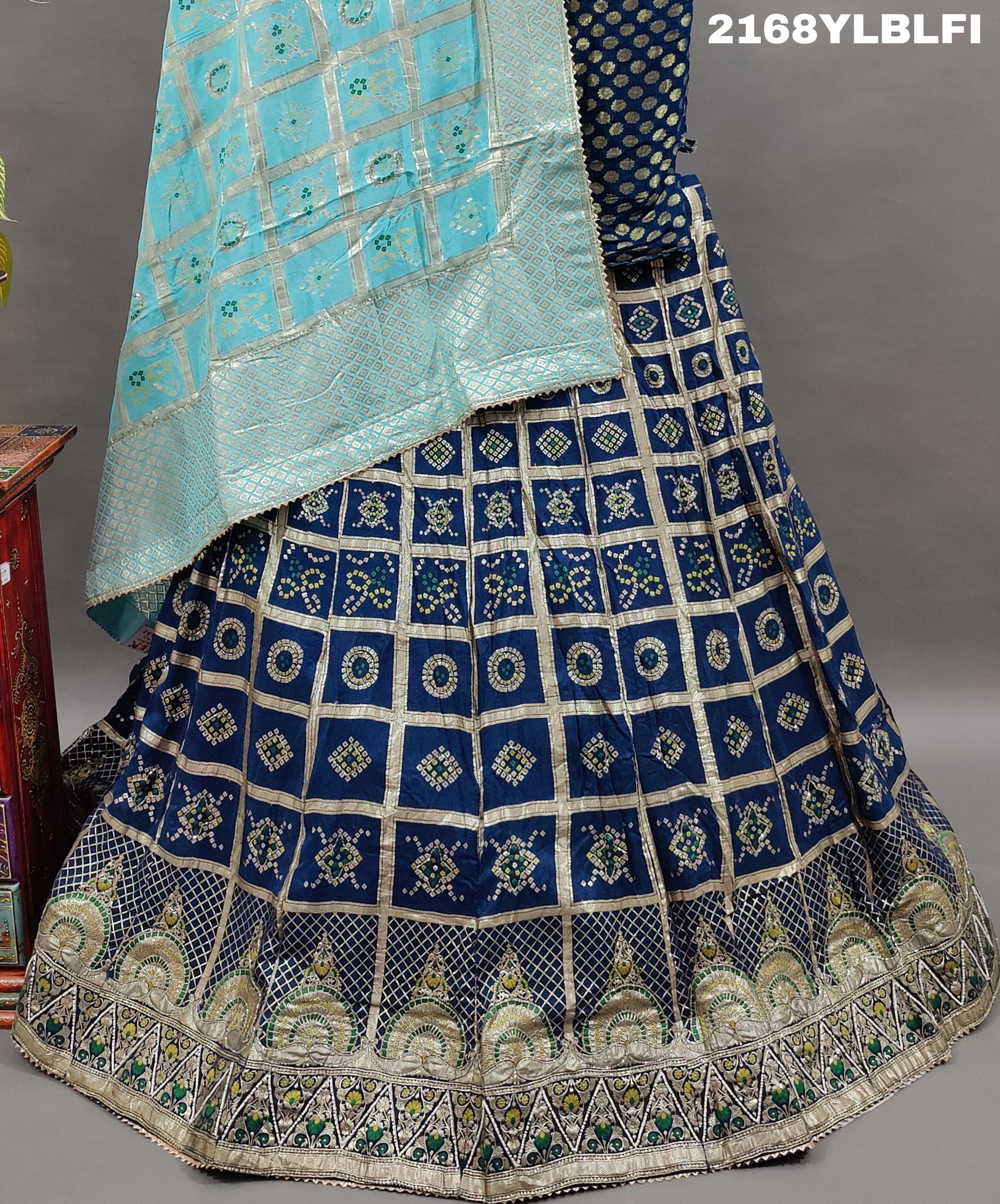 A traditional Indian lehenga with a blue and silver silk base and detailed cutdana work