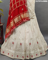 A traditional Indian lehenga in cream and red color with gotapatti work