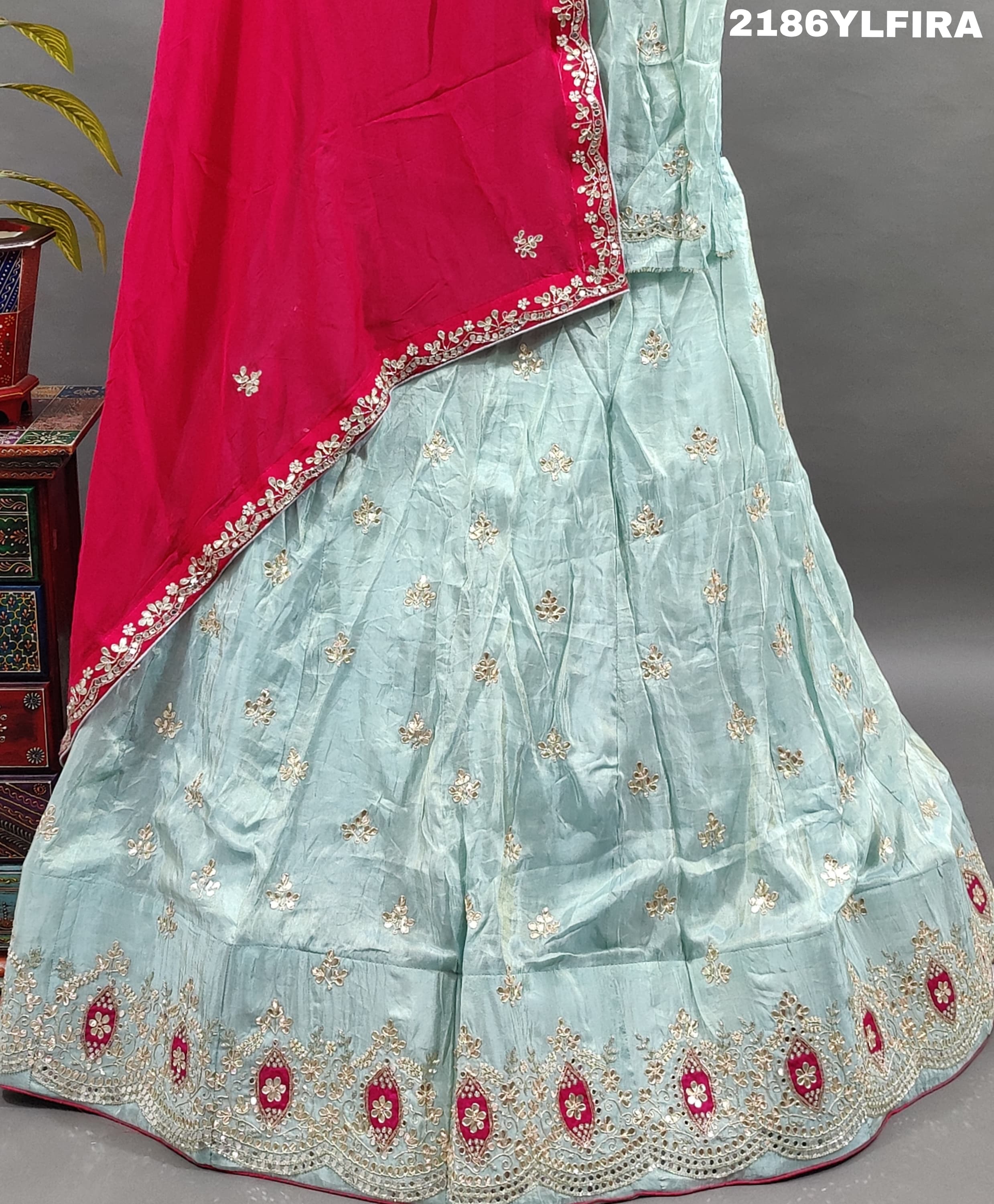A Bollywood style blue Lehenga with pink embellishments and a red dupatta.