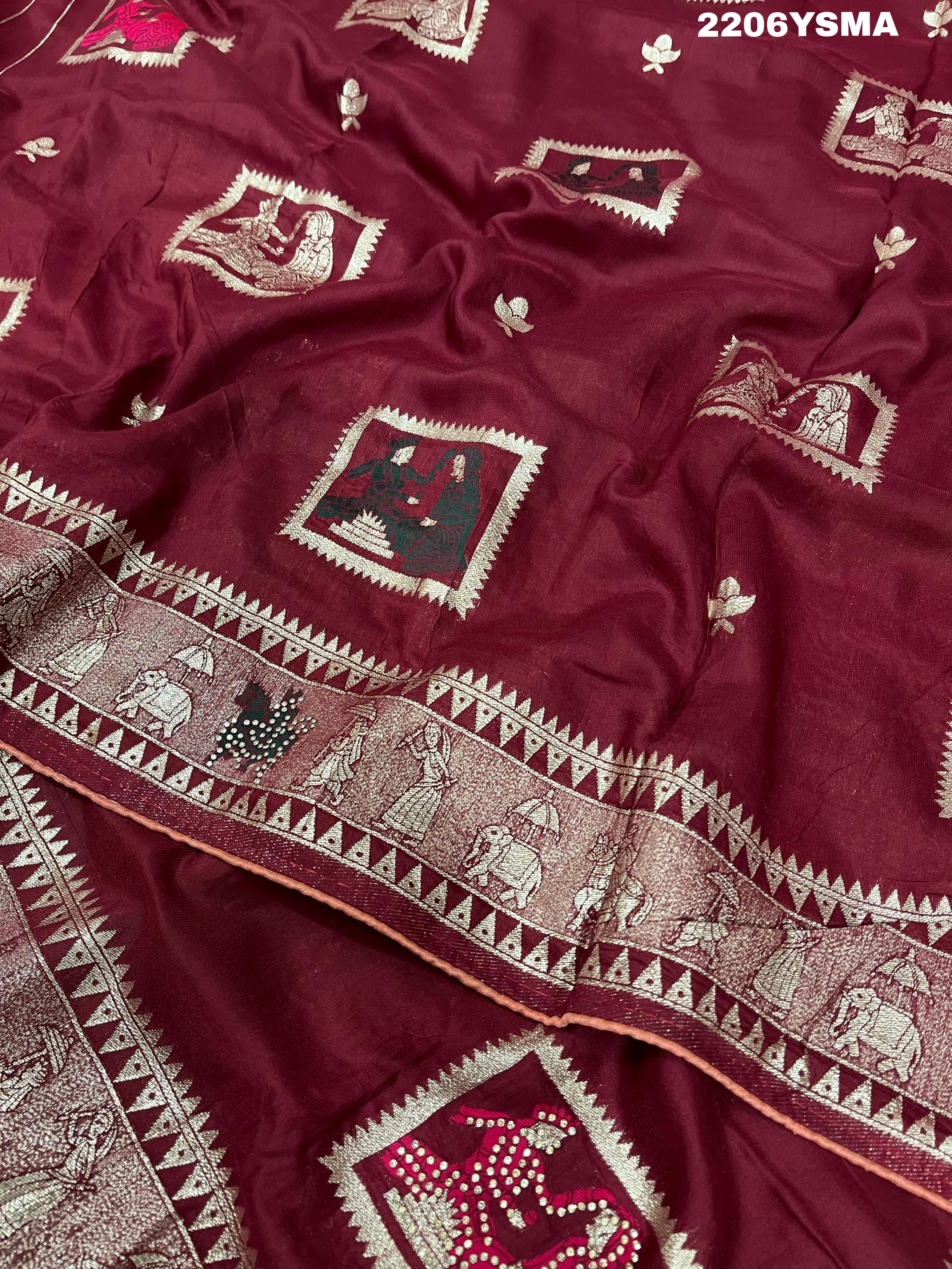 A wine colored Dola Silk saree with Banarasi style stone work, depicting traditional Indian motifs and characters.