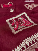 A wine colored Dola Silk saree with Banarasi style stone work, depicting traditional Indian motifs and characters.
