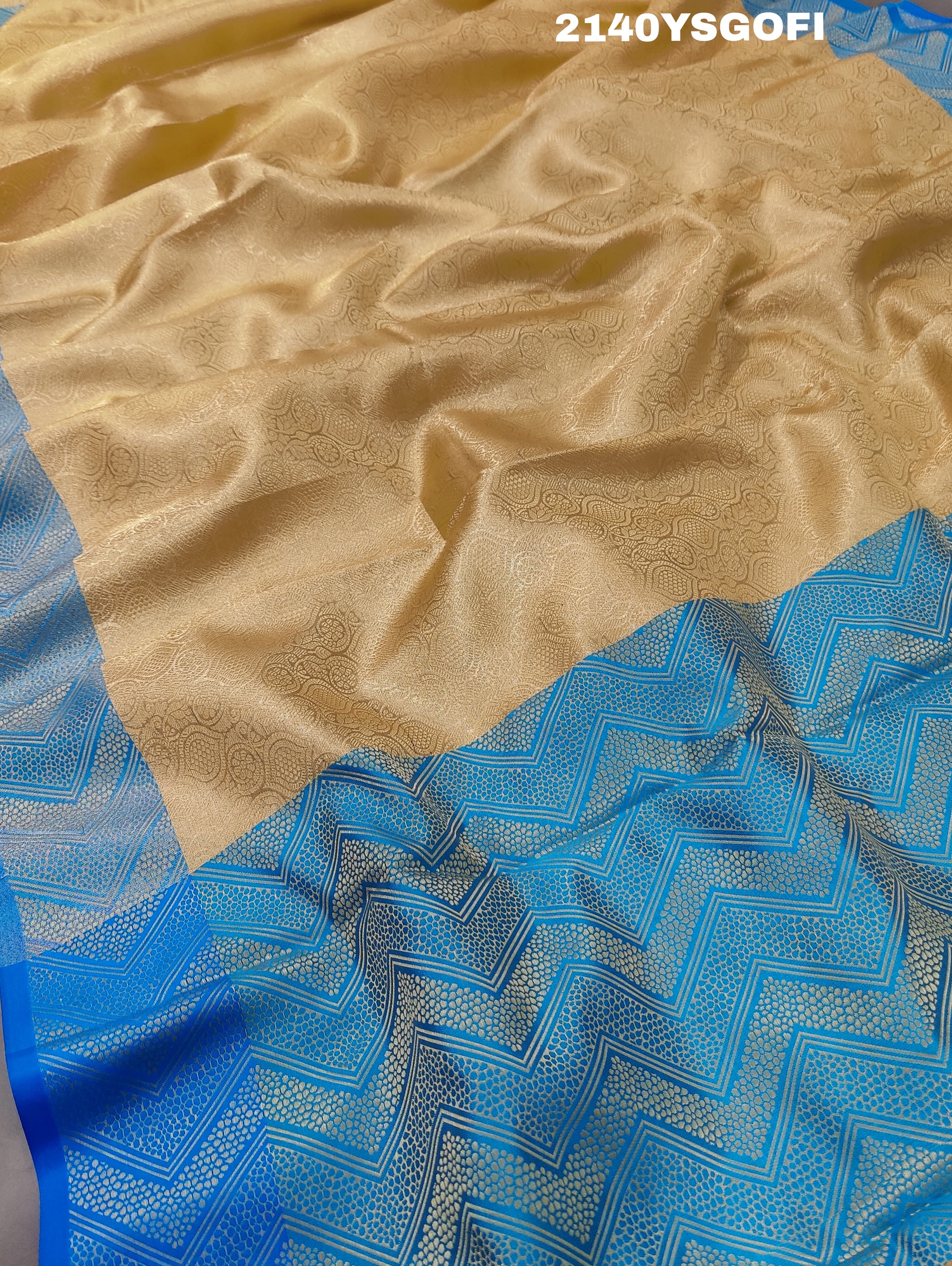 A tissue silk banarasi saree with zari weaving, featuring a blue and gold design on a beige fabric, meant for party or casual wear.