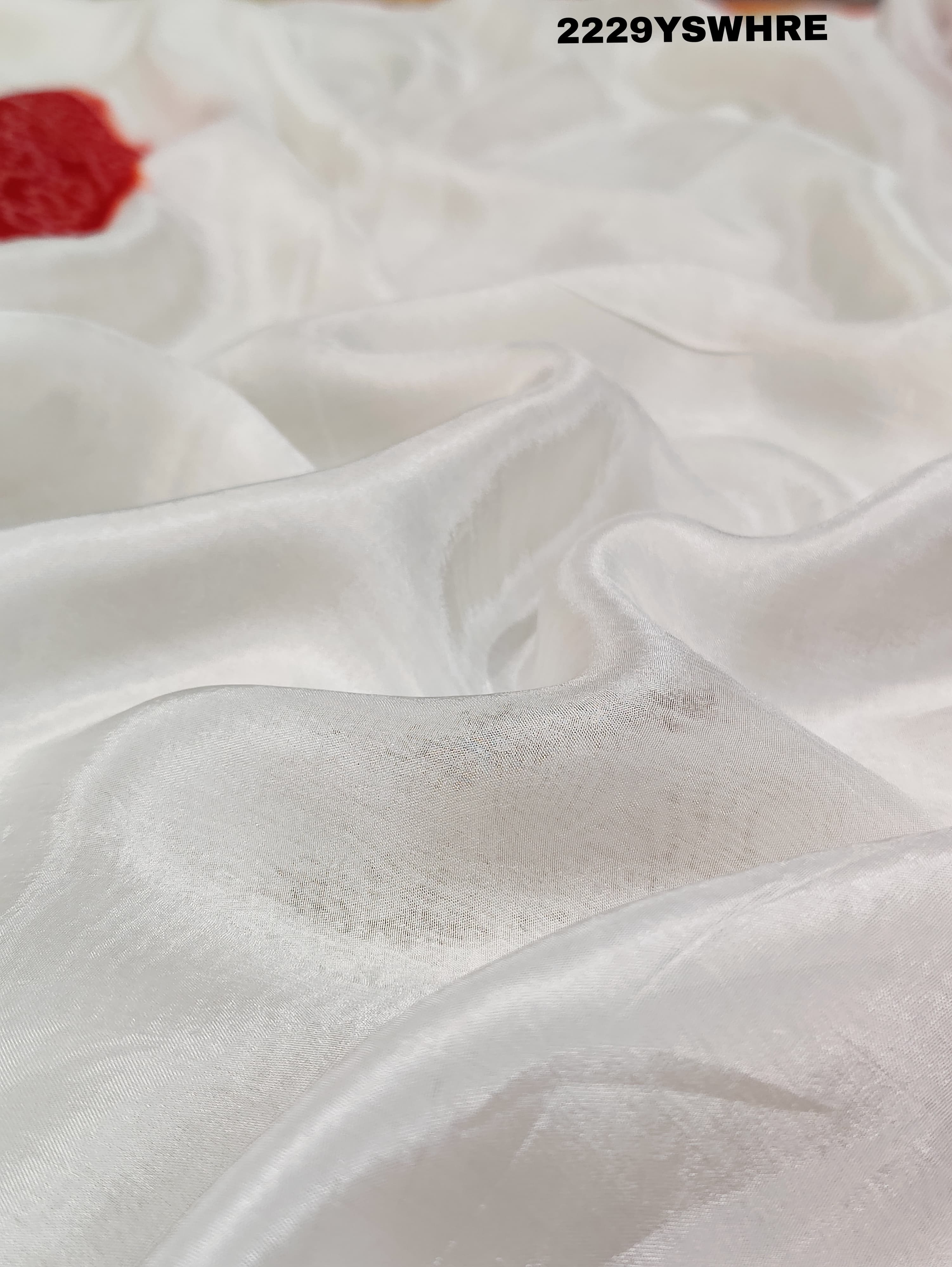A traditional saree with red and white colors and intricate patterns, predominantly red at one end with a floral design.