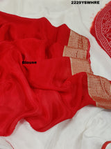 A traditional saree with red and white colors and intricate patterns, predominantly red at one end with a floral design.