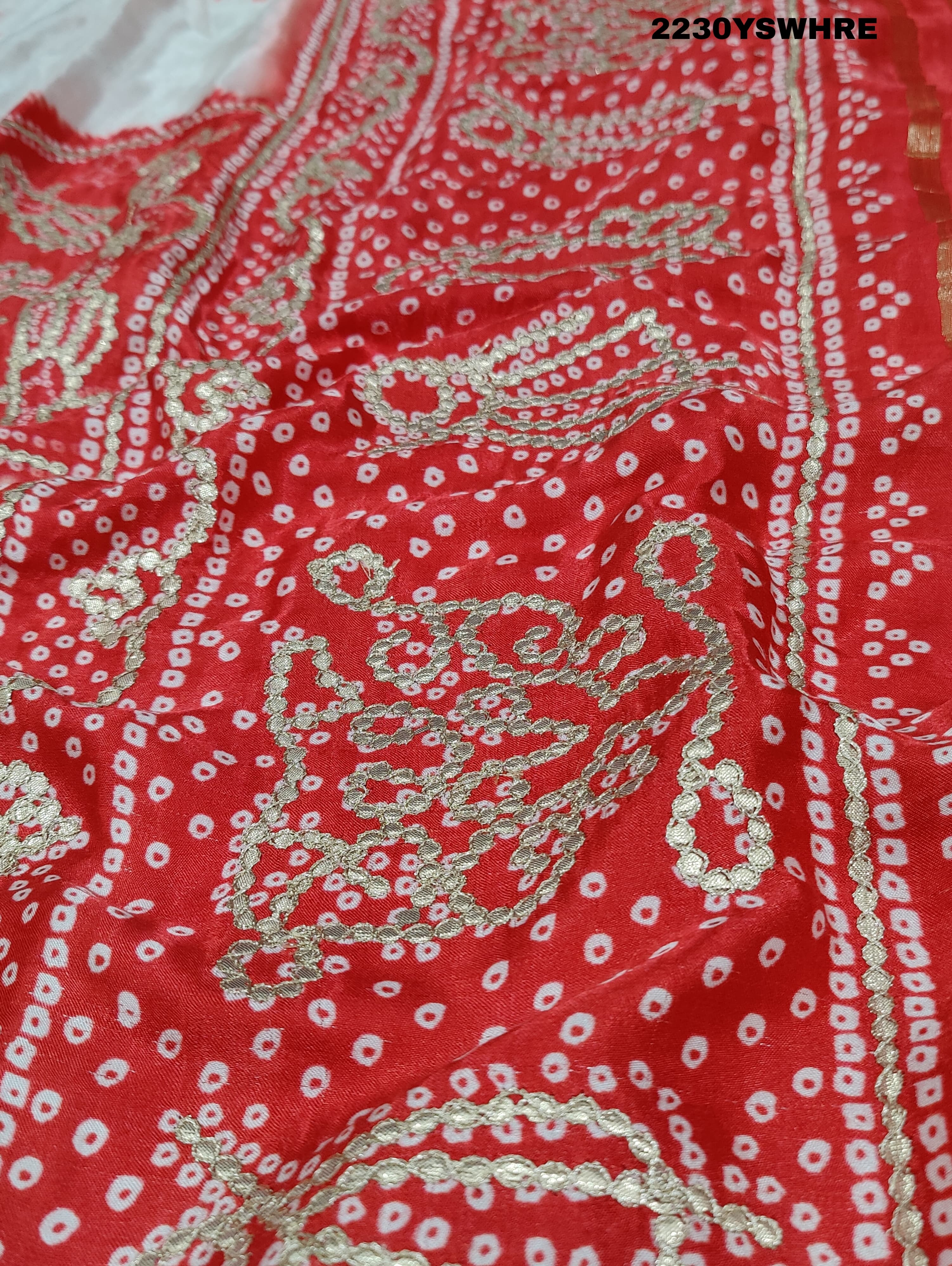 A red and white bandhani style saree with gotapatti work