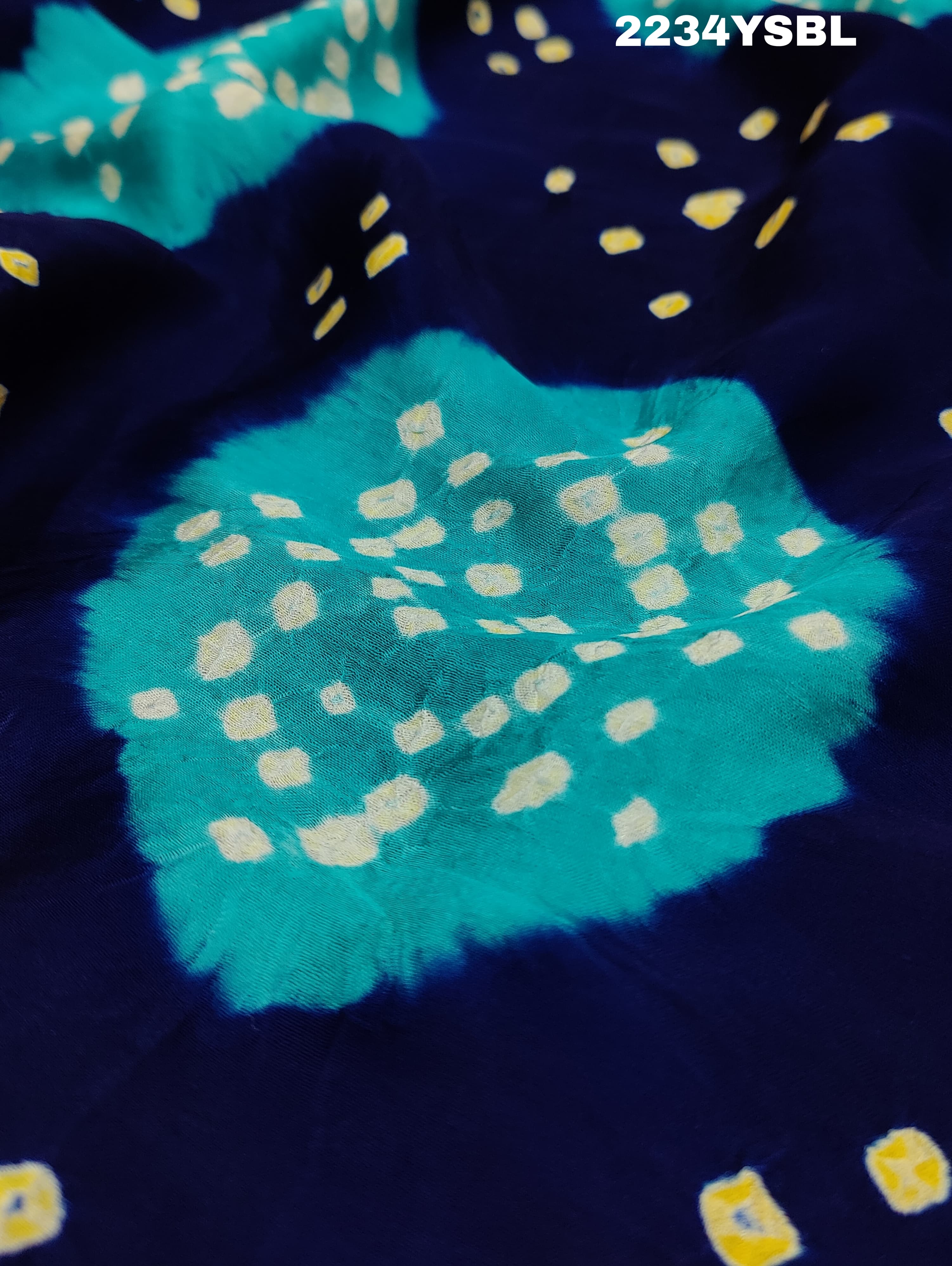A blue and green bandhani style saree with a floral pattern