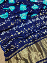 A blue and green bandhani style saree with a floral pattern
