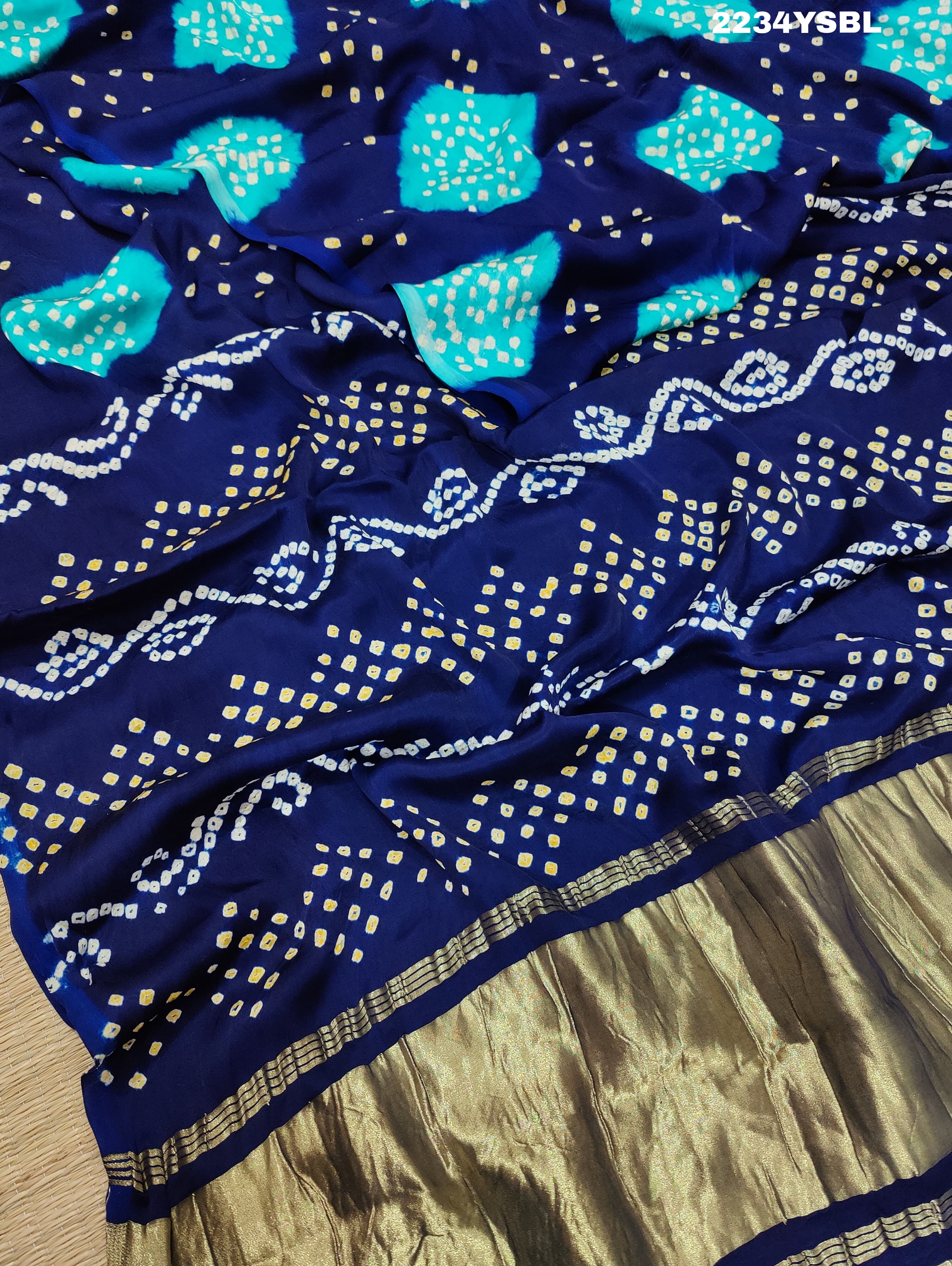 A blue and green bandhani style saree with a floral pattern