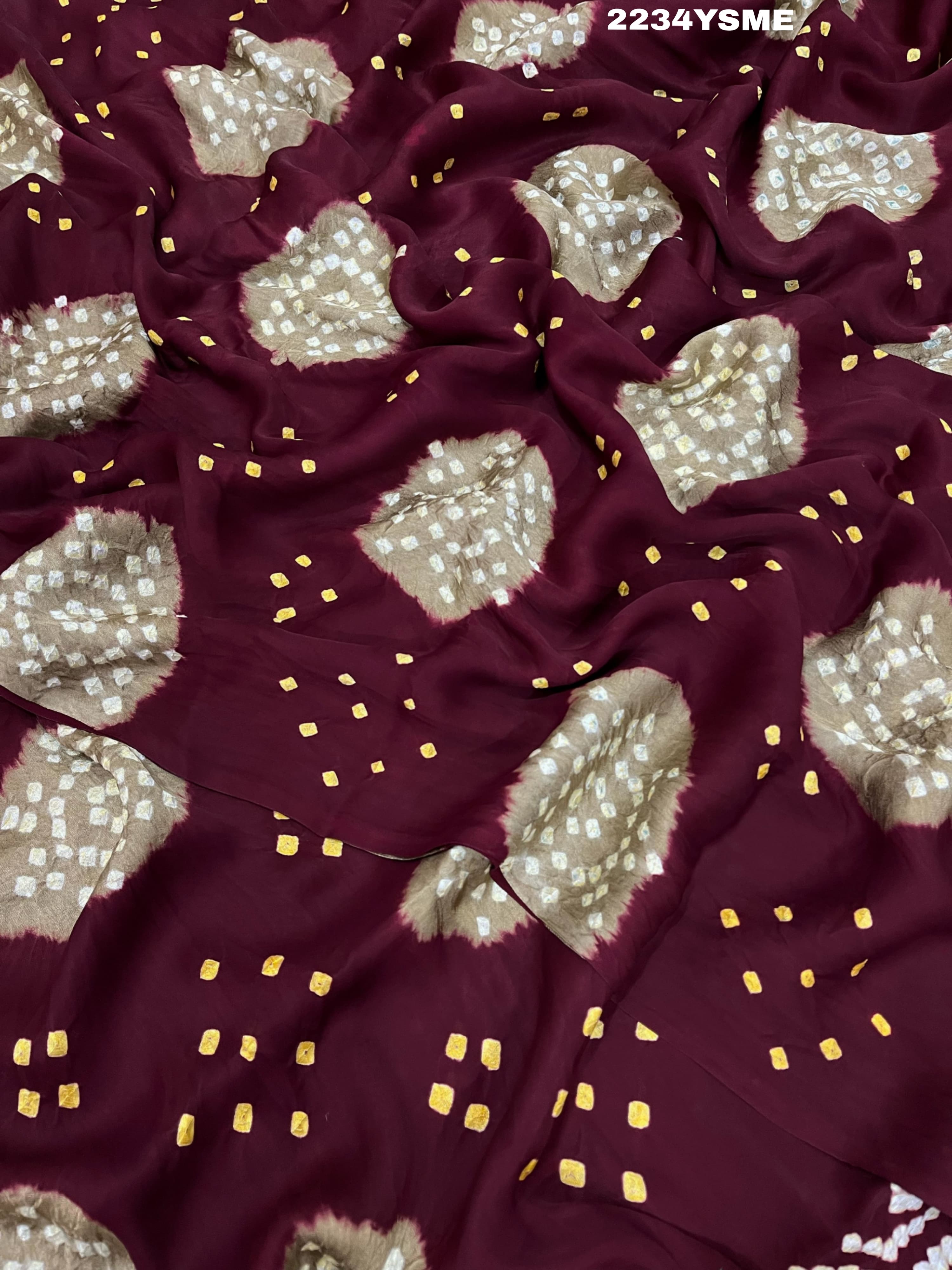 A maroon and white colored bandhani style saree