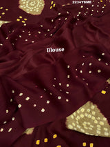 A maroon and white colored bandhani style saree