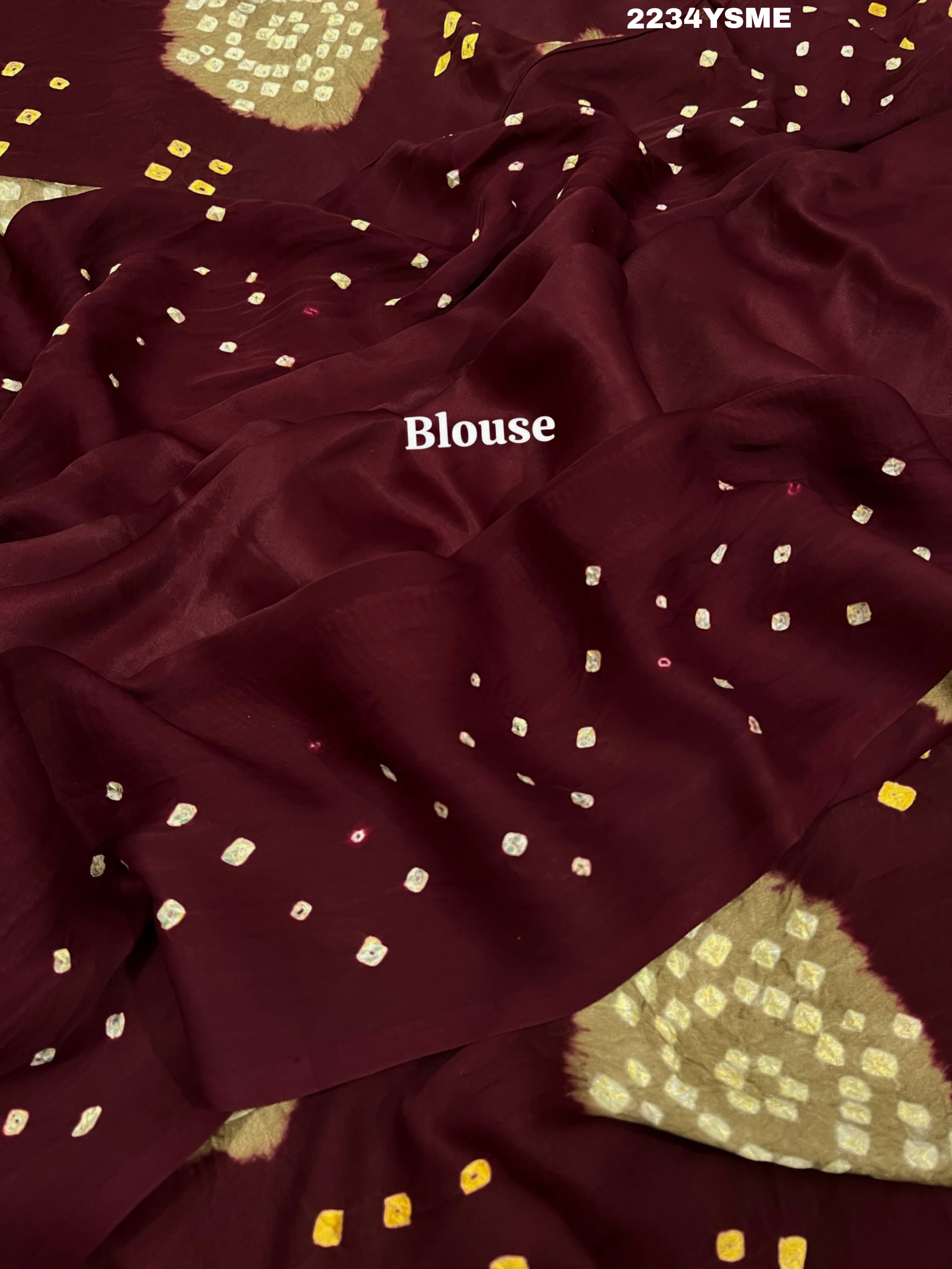 A maroon and white colored bandhani style saree
