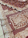 A maroon and gold saree withbandhej patterns and gotapatti handwork.