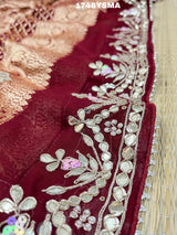 A maroon and gold saree with intricate geometric bandhej patterns and gotapatti handwork.