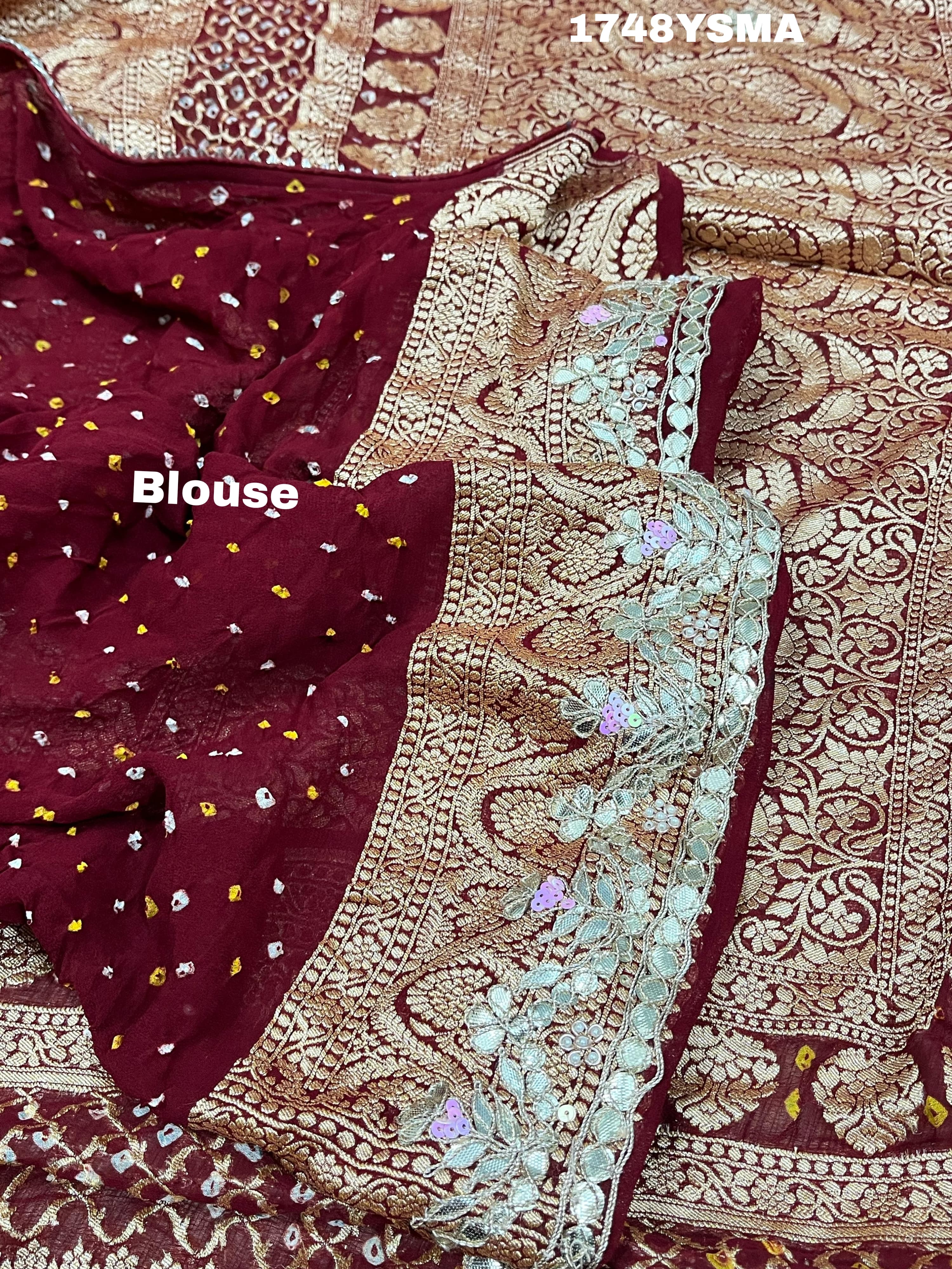 A maroon and gold saree with intricate geometric bandhej patterns and gotapatti handwork.