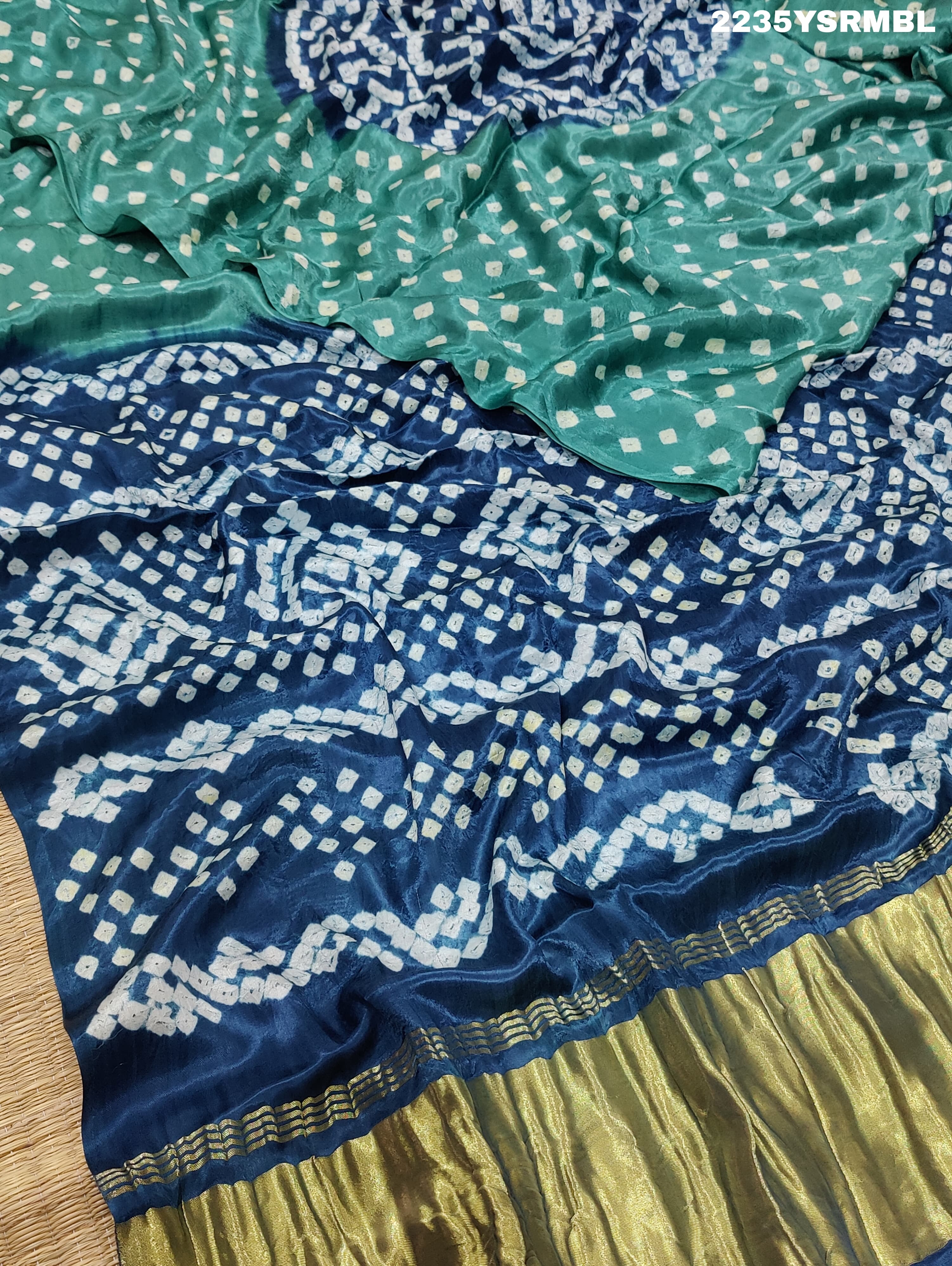 A silk fabric saree with bandhani style patterns in blue and green colors