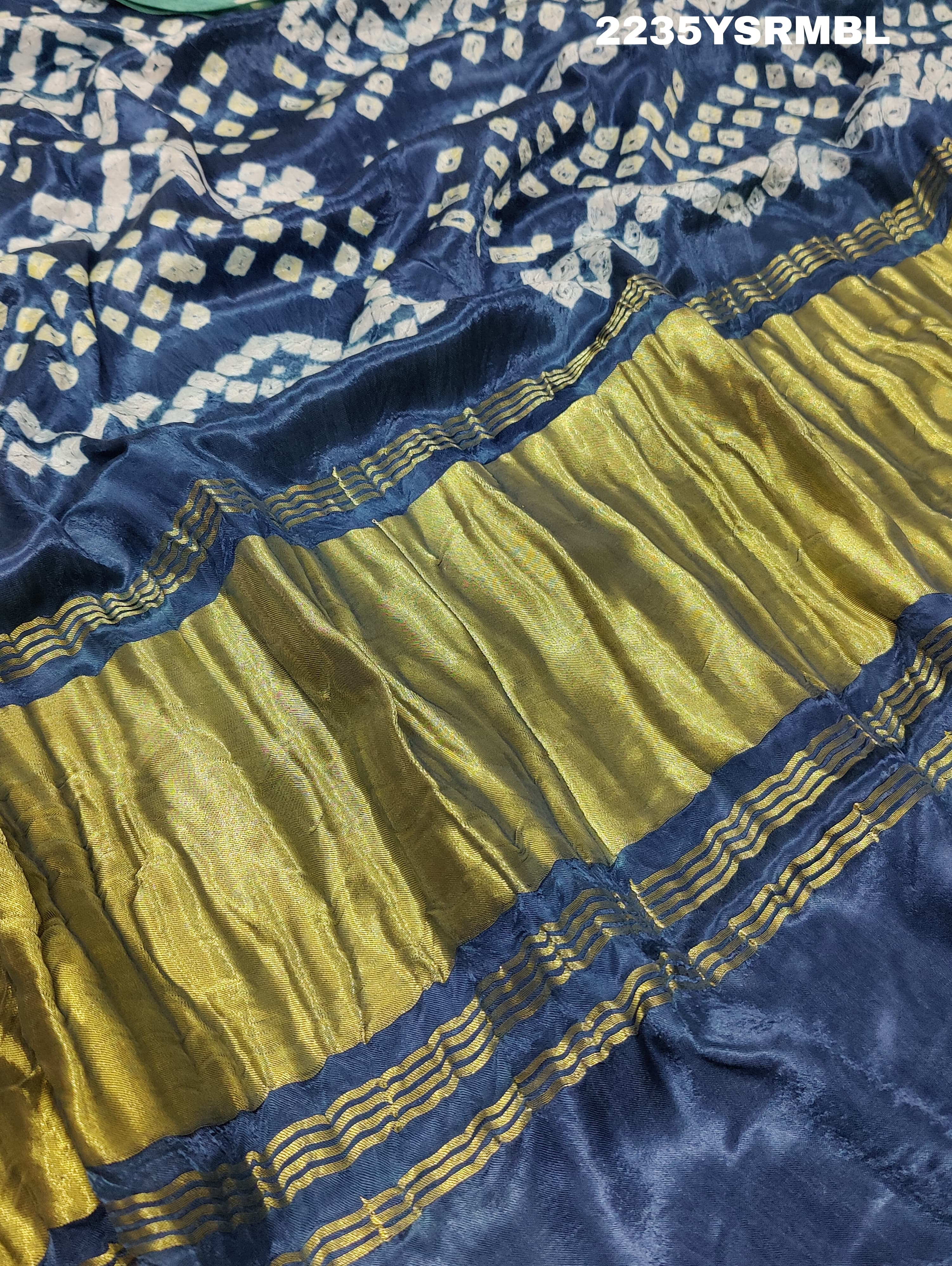 A silk fabric saree with bandhani style patterns in blue and green colors