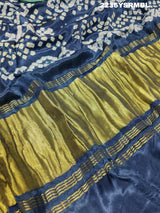 A silk fabric saree with bandhani style patterns in blue and green colors