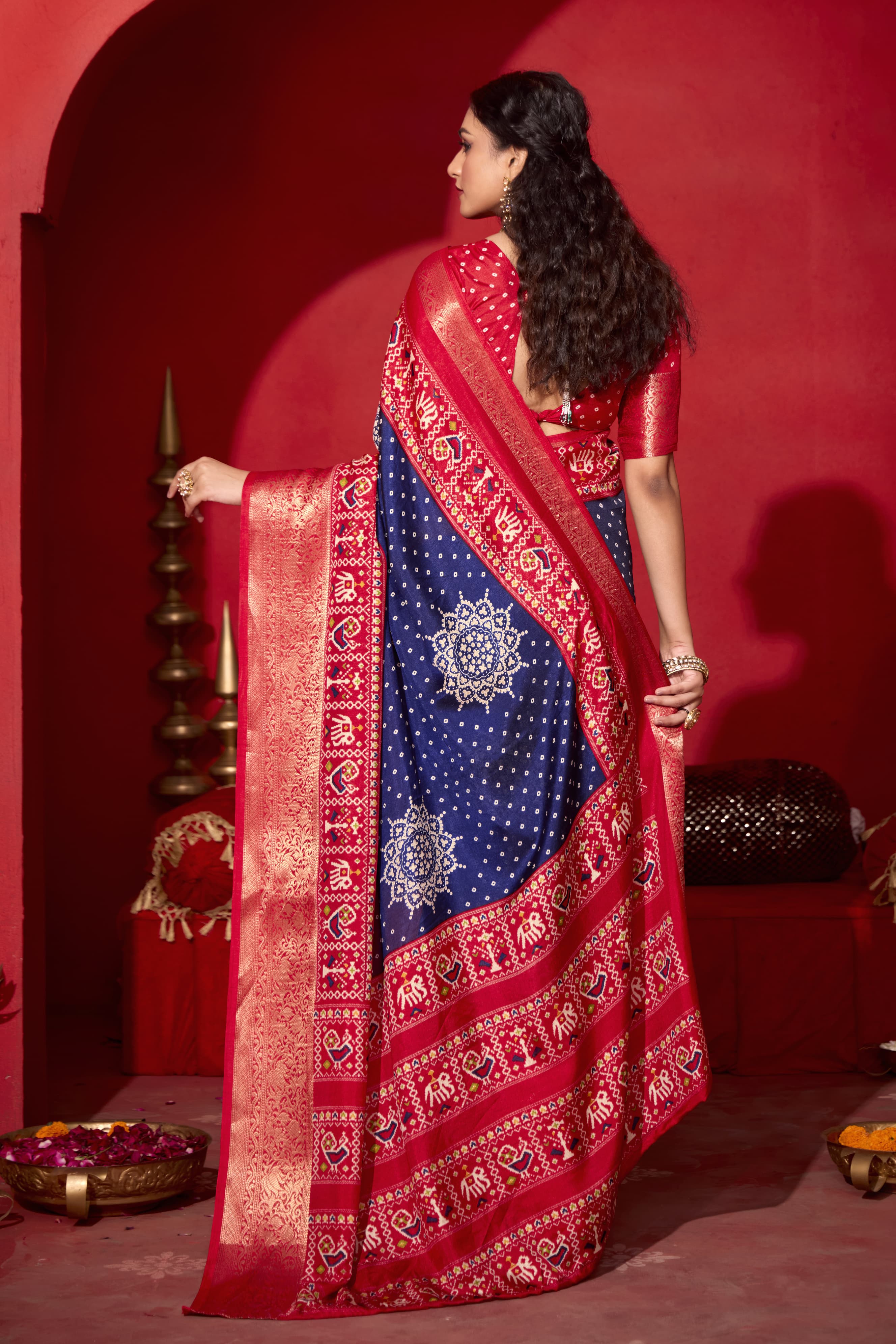 A blue and red bandhani print pashmina silk saree with patola print border