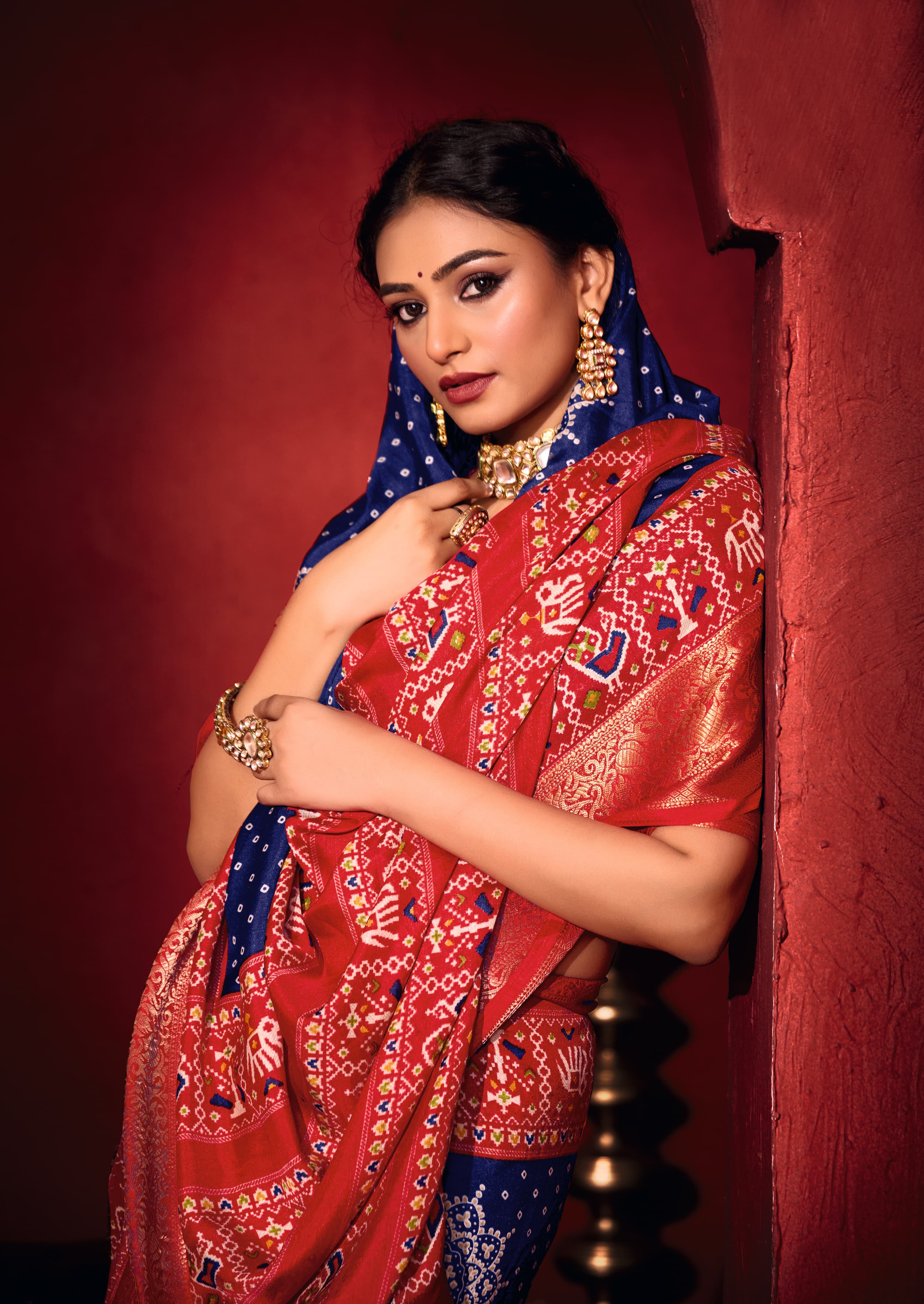 A blue and red bandhani print pashmina silk saree with patola print border