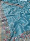 A blue saree with tissue silk fabric and Bollywood-style sequence embroidery work, including floral patterns and a border.