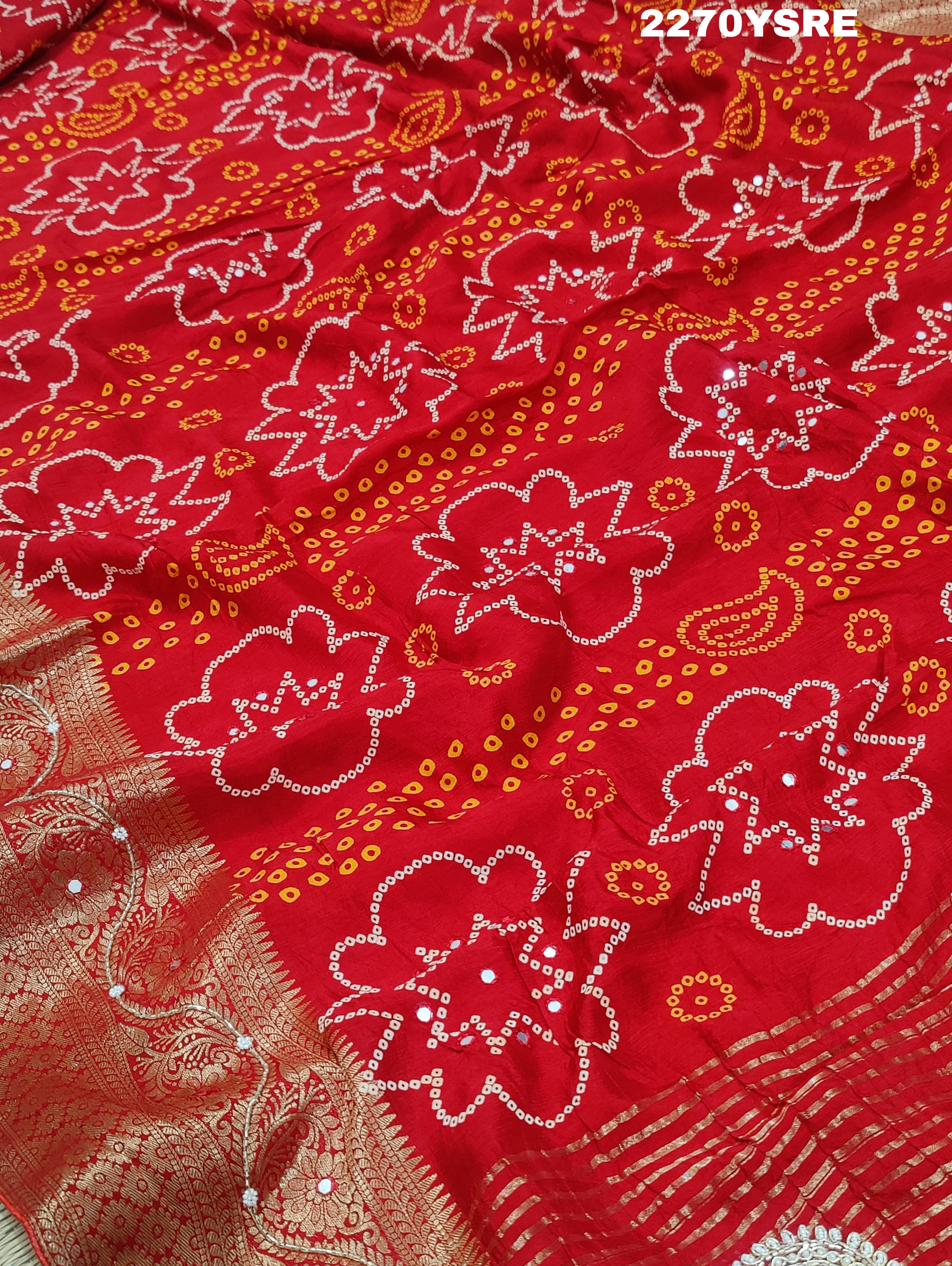A red and silver bandhani style Dola silk saree with cutdana work and floral patterns, along with a golden border.