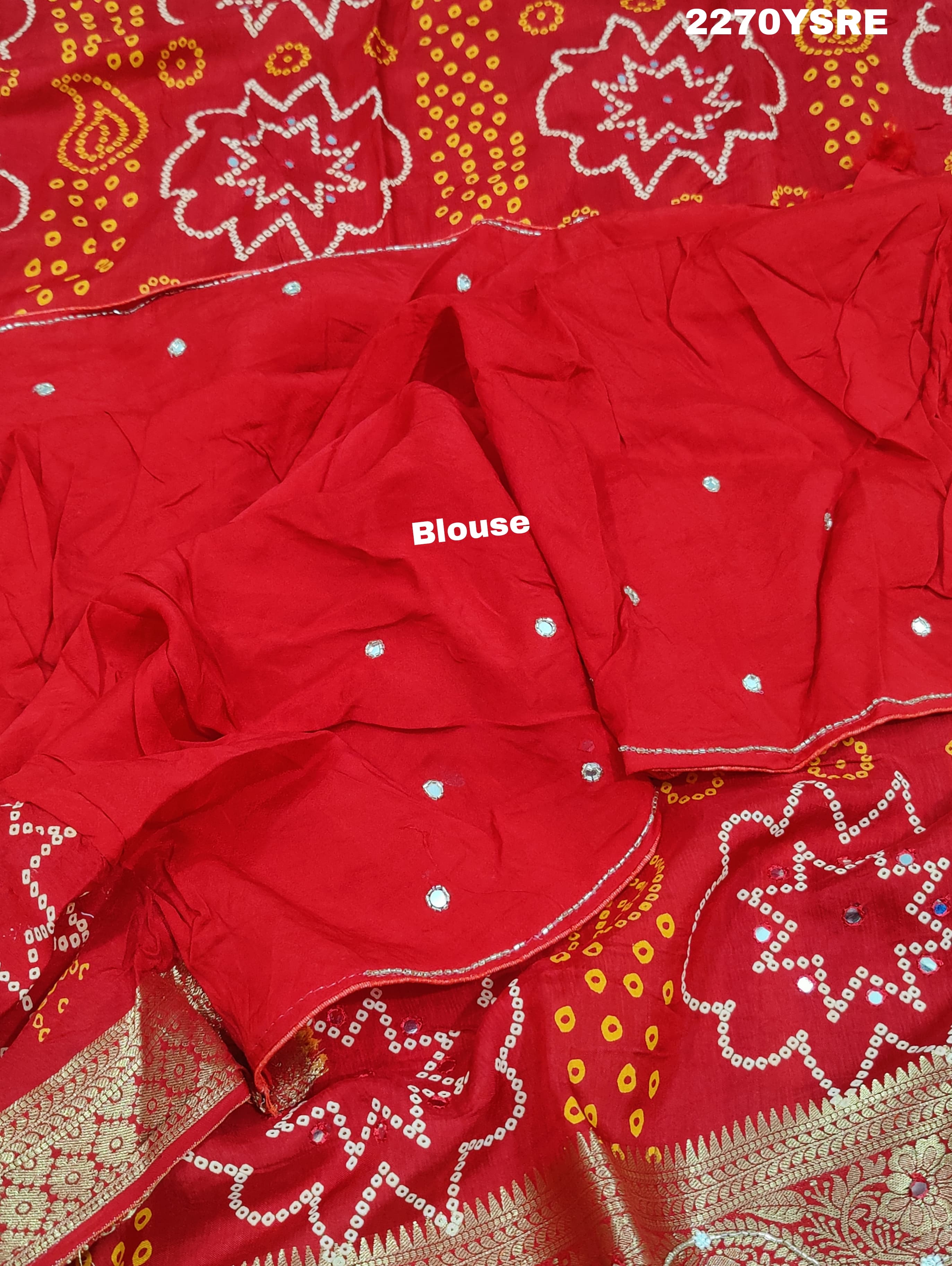 A red and silver bandhani style Dola silk saree with cutdana work and floral patterns, along with a golden border.