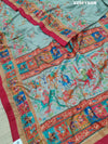 A cotton silk saree with a kalamkari style foil print design featuring multiple colors including red, green, and beige.