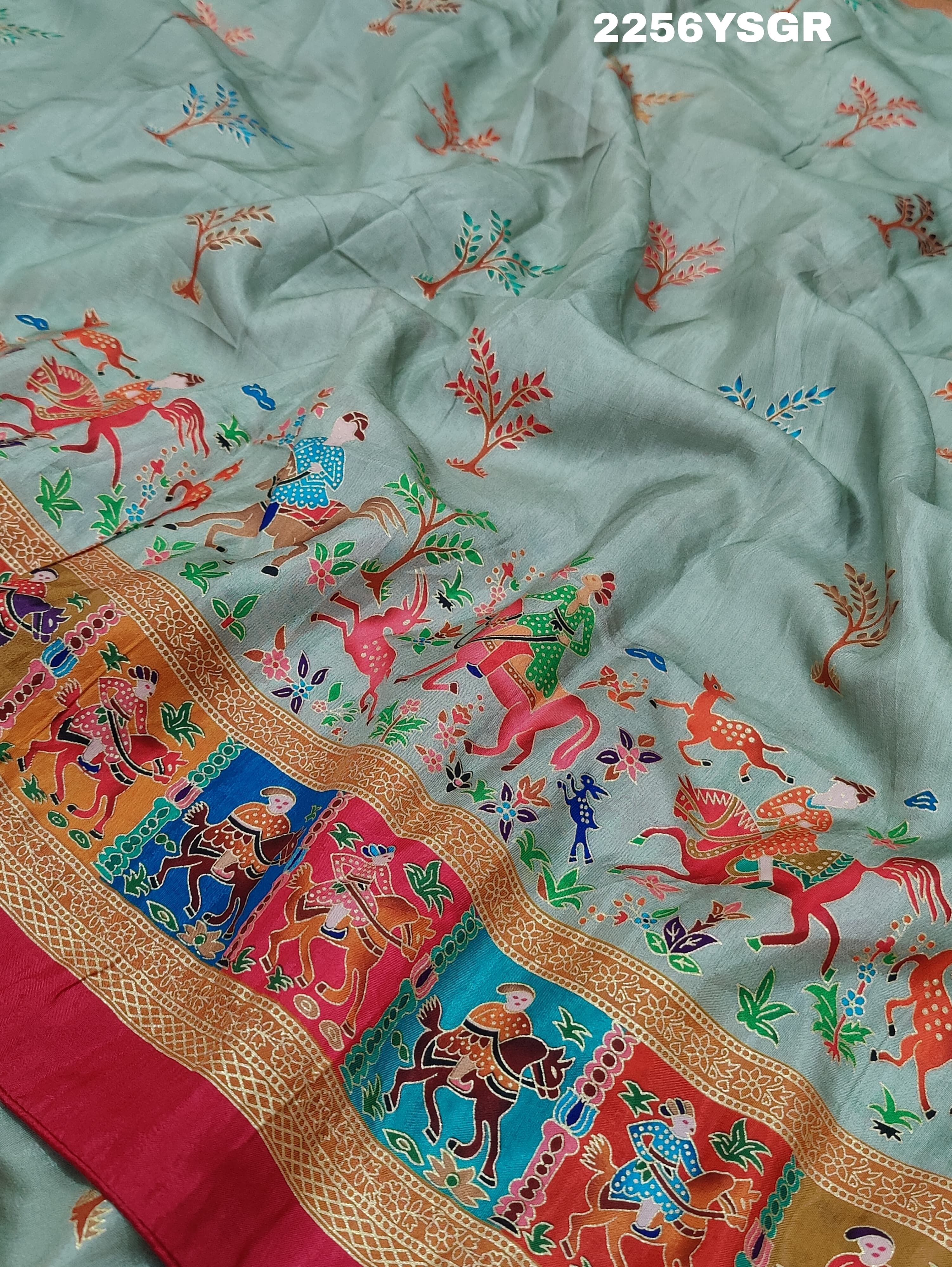 A cotton silk saree with a kalamkari style foil print design featuring multiple colors including red, green, and beige.