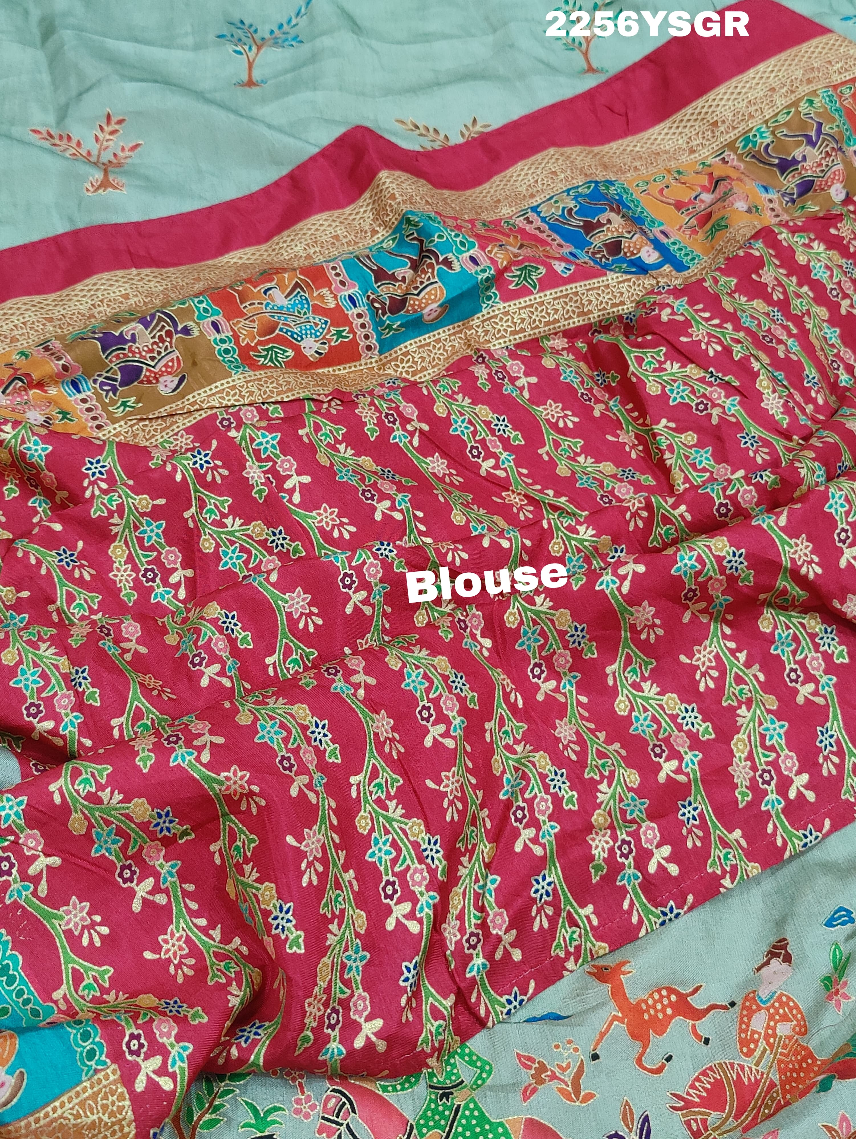 A cotton silk saree with a kalamkari style foil print design featuring multiple colors including red, green, and beige.