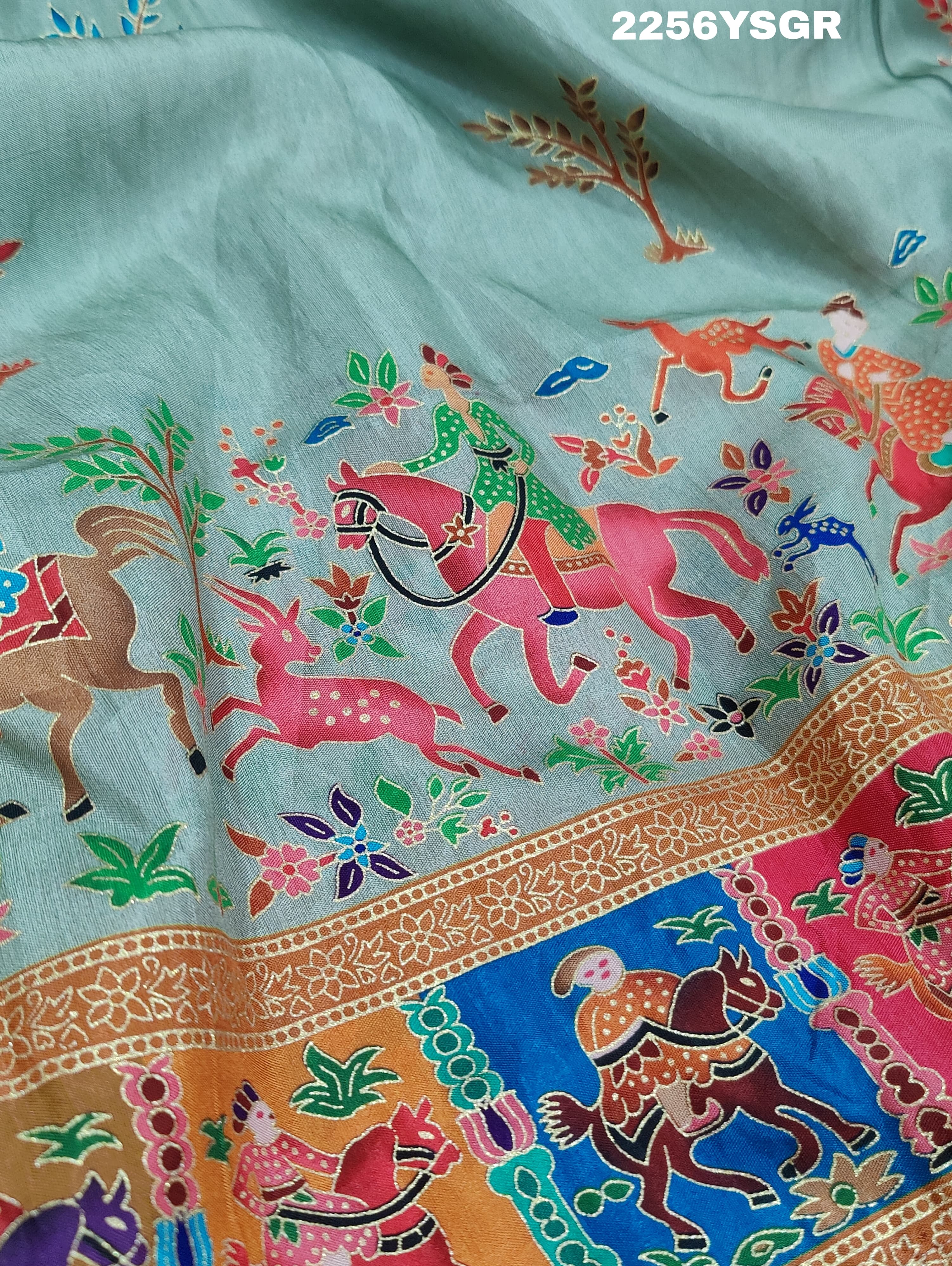A cotton silk saree with a kalamkari style foil print design featuring multiple colors including red, green, and beige.