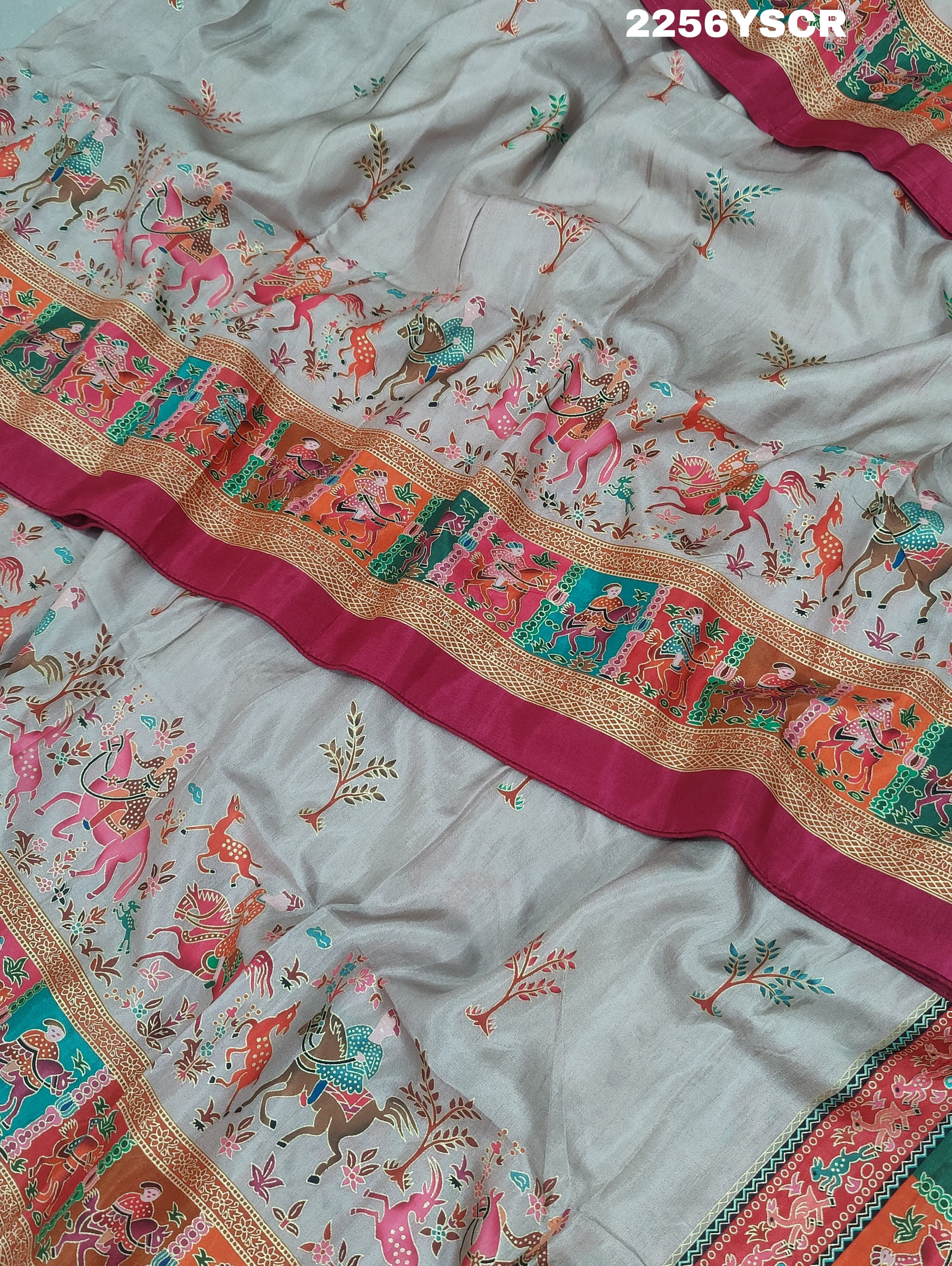 A cotton silk saree with a kalamkari style foil print design in multiple colors including cream, red, and green.