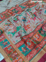 A cotton silk saree with a kalamkari style foil print design in multiple colors including cream, red, and green.