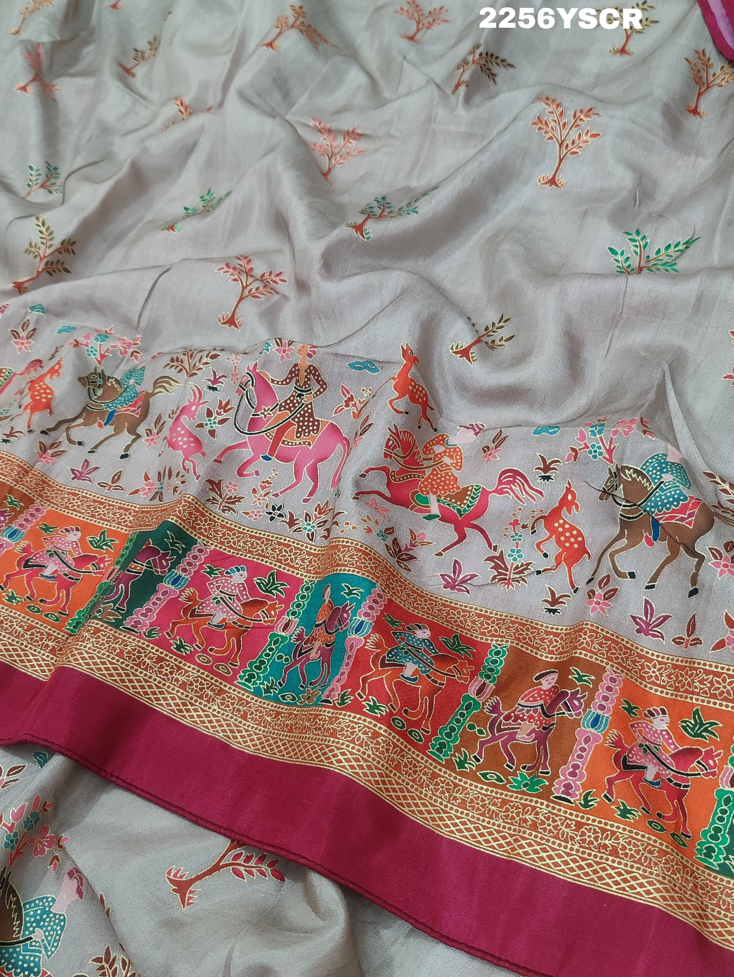 A cotton silk saree with a kalamkari style foil print design in multiple colors including cream, red, and green.